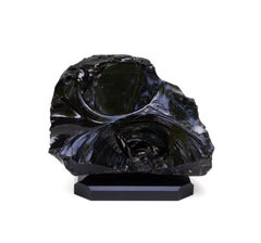 Skulpturaler schwarzer Obsidian in Naturform auf schwarzem Sockel