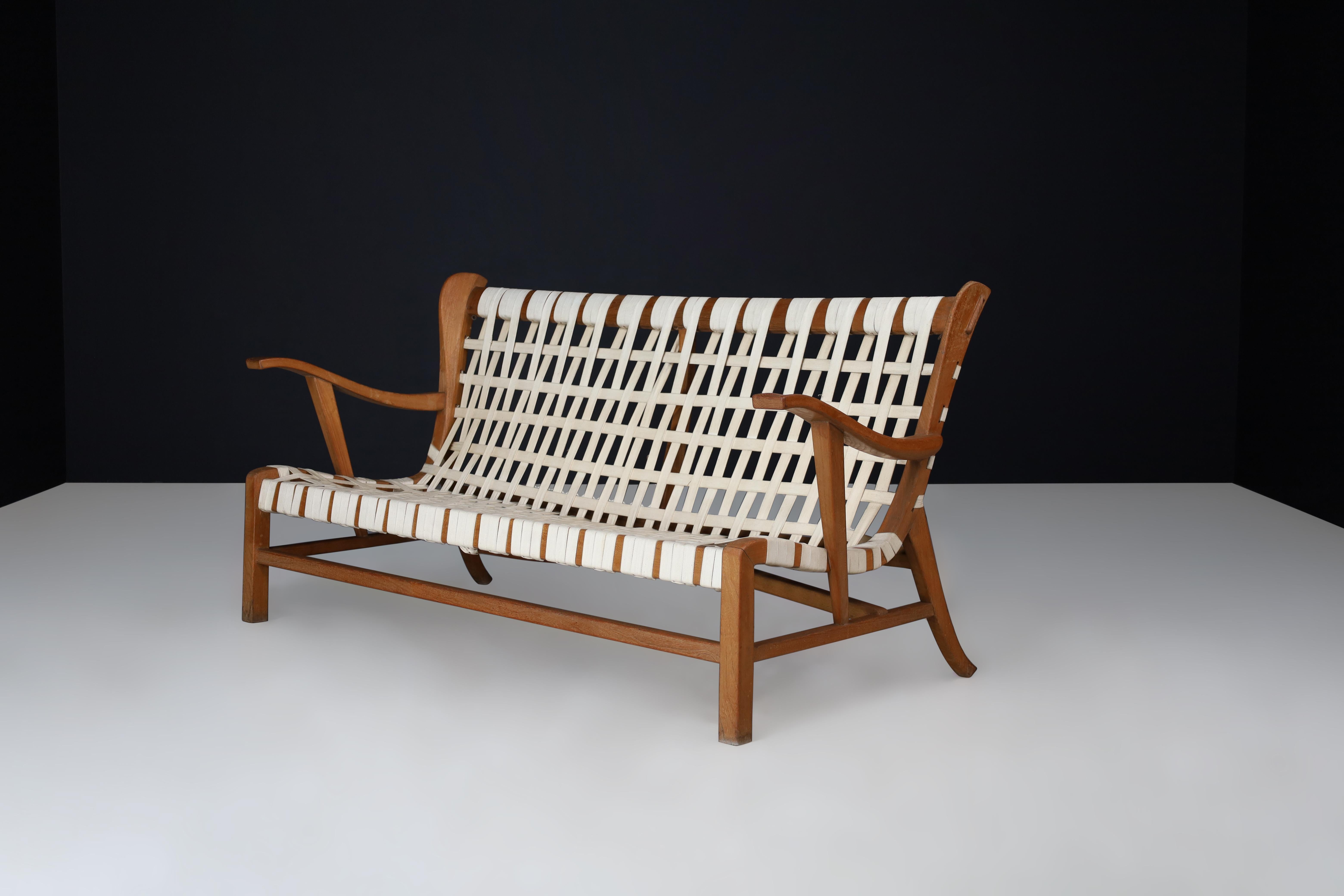 Sculptural oak Lounge Sofa by Guglielmo Pecorini, Italy, the 1950s

This describes a midcentury sculptural sofa designed by Guglielmo Pecorini in the 1950s. The sofa is made with an oak frame and linen straps, exhibiting signs of aging and use, but