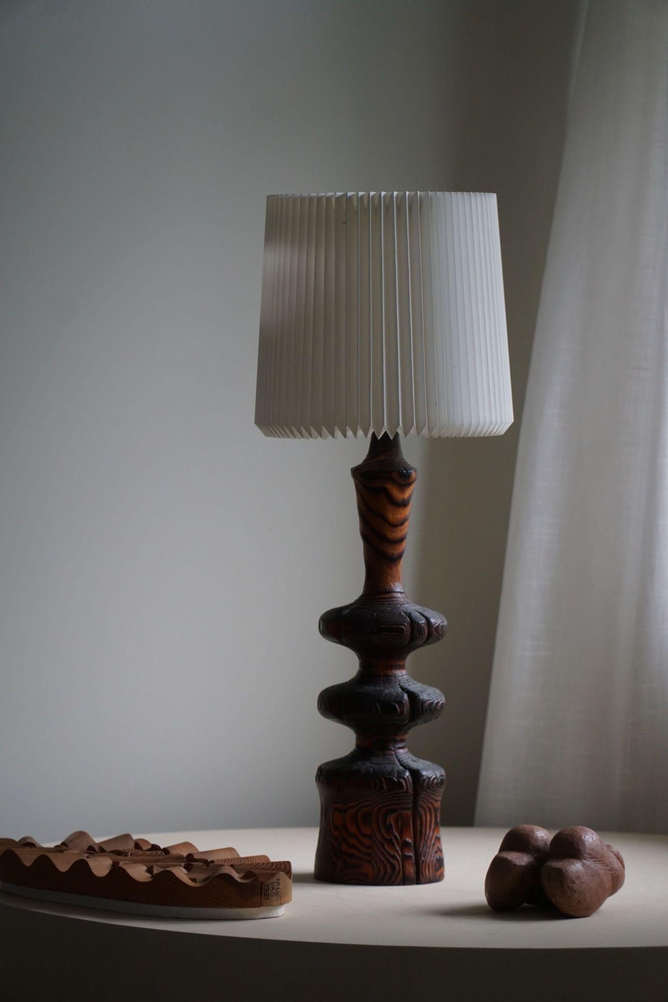 Organic shaped table lamp in burned pine wood. Hand crafted in Scandinavia by an unknown cabinetmaker, ca 1960s.

The overall impression of this mid century table lamp is really good.
It will complement many interior styles. A modern, Classic,