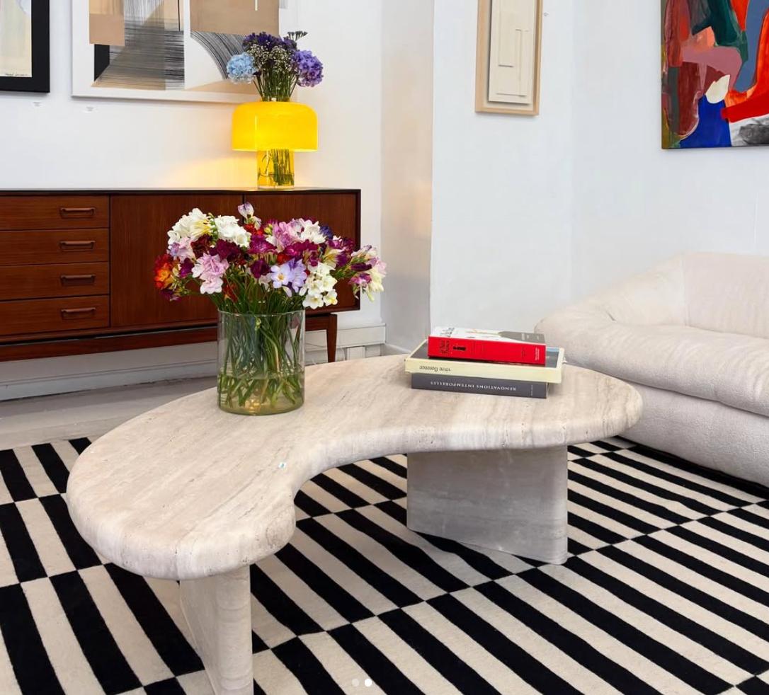 Fabriquée à partir d'un seul matériau, cette table basse présente un plateau de 4 cm d'épaisseur avec un bord arrondi doux, soutenu par deux pieds organiques sculptés qui lui confèrent une présence à la fois ancrée et fluide.

Après des années