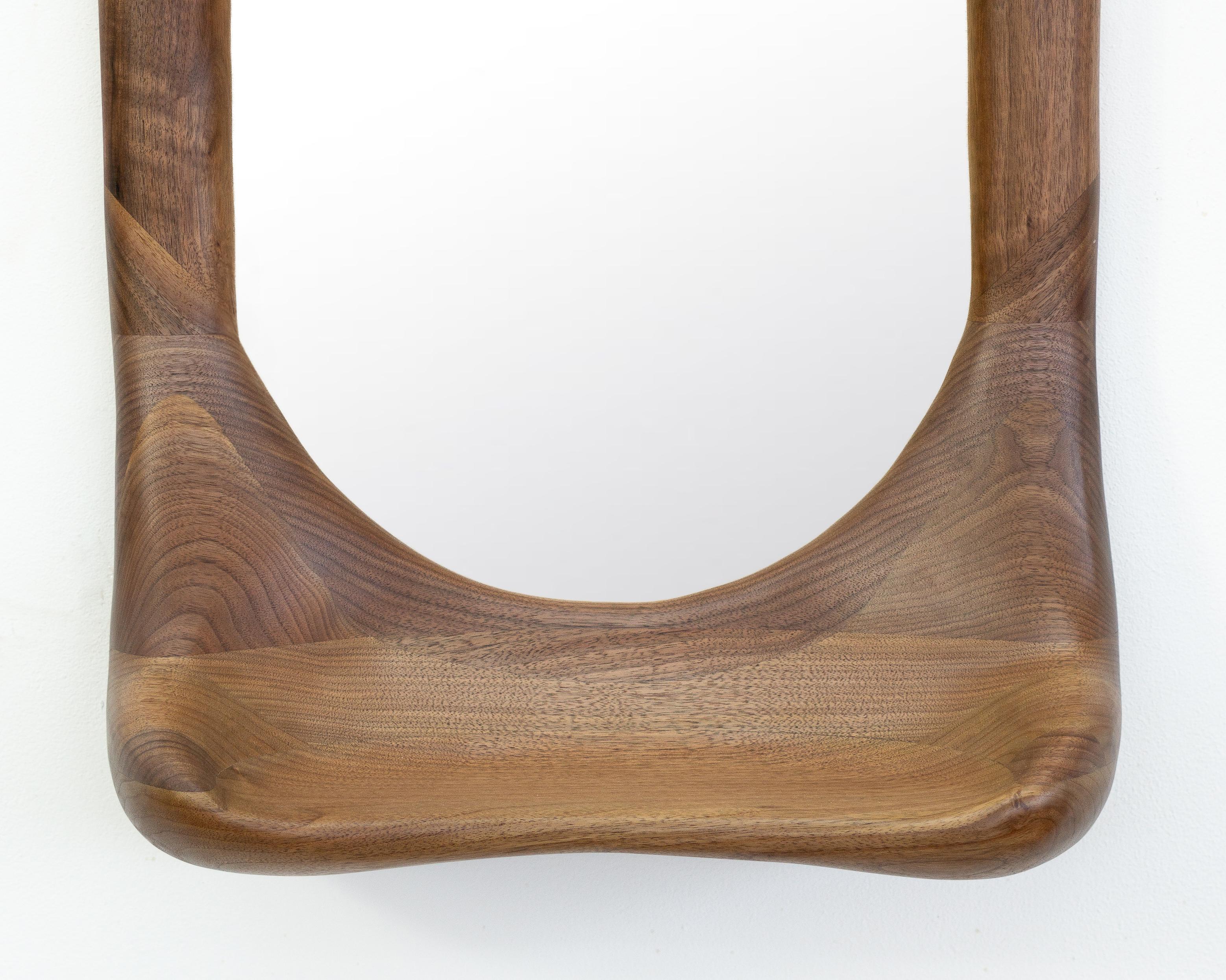 The frame of the mirror is shaped using various hand tools, making each piece unique with its own distinctive wood grain. The mirror is made from high-quality walnut and finished with a hardwax oil.

The mirror is mounted on the wall by hanging it