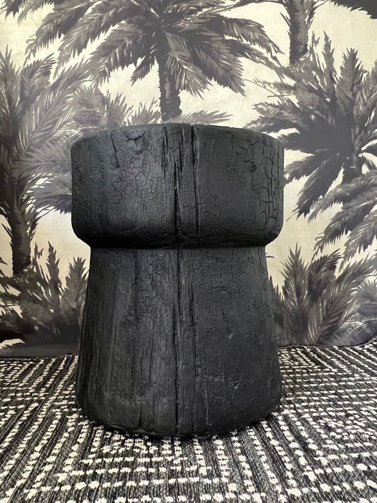 Organic Modern indoor/outdoor side table with sculptural drum form. The accent table is comprised of concrete resin and magnesium oxide with a faux wood texture resembling a natural wood stump. Has weather resistant finish in matte black.