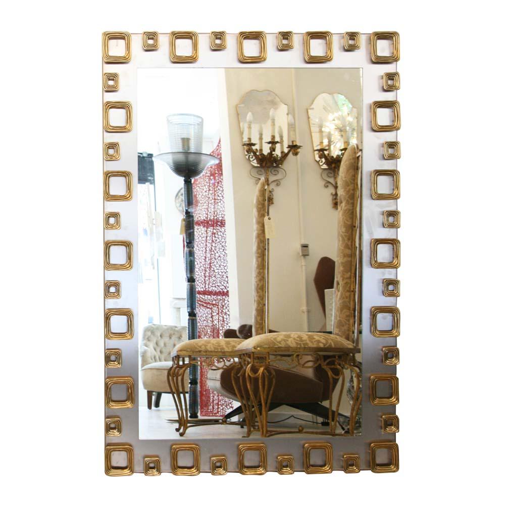 A very beautiful vintage sculptural mirror. Cast steel frame with ribbed geometric brass decorations all around the frame. A very chic and iconic 1970s Italian design. A truly talking piece extremely decorative.