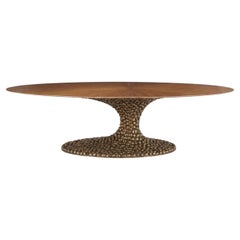 Mesa de comedor ovalada de diseño escultural de Albino Miranda, con tablero de nogal y base de fundición