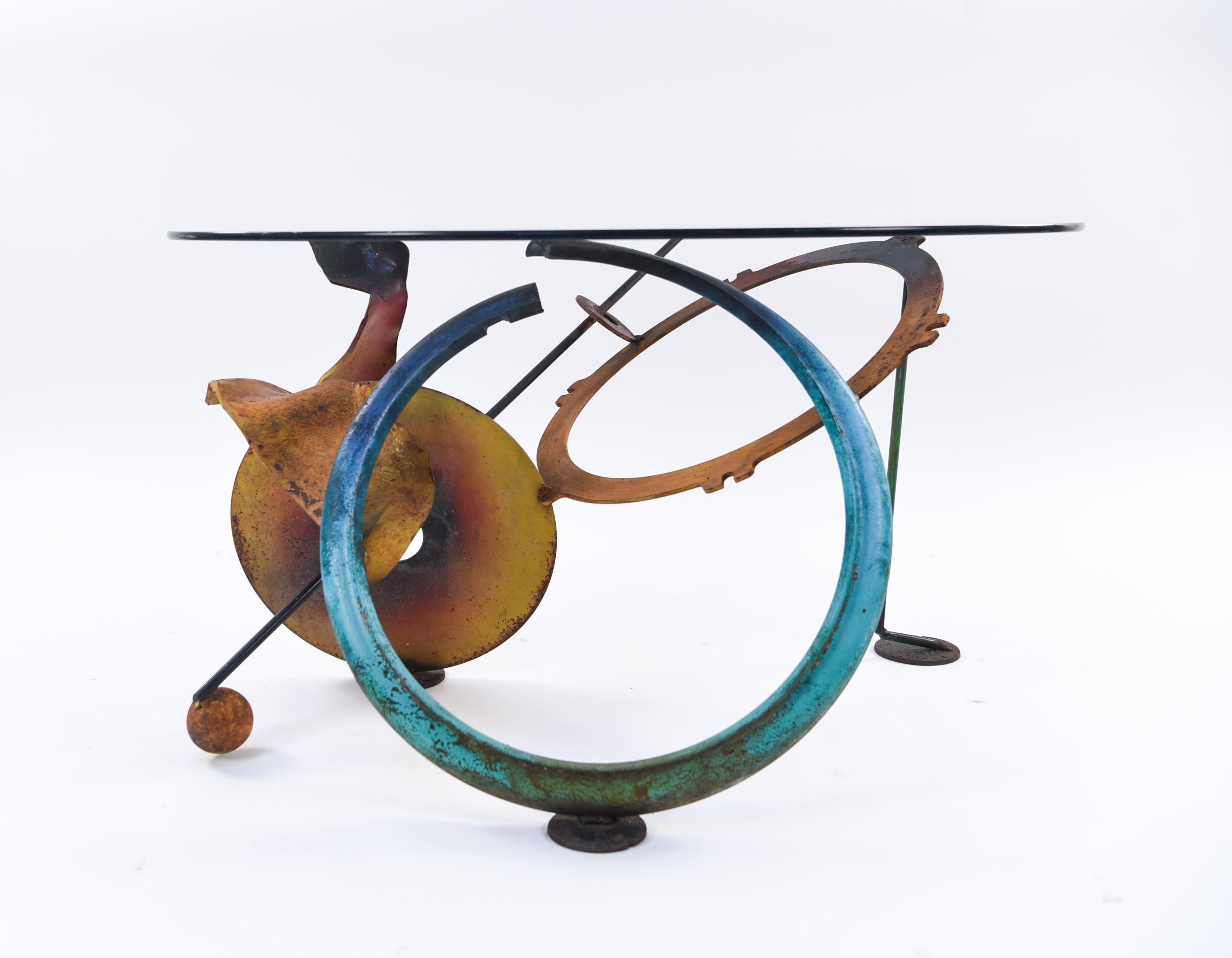 Painted iron and glass. Canadian export stamp inside blue ring.
This sculptural table, with its asymmetrical lines and playful color, is like a Kandinsky painting come to life. This piece would make a statement as the center table in an