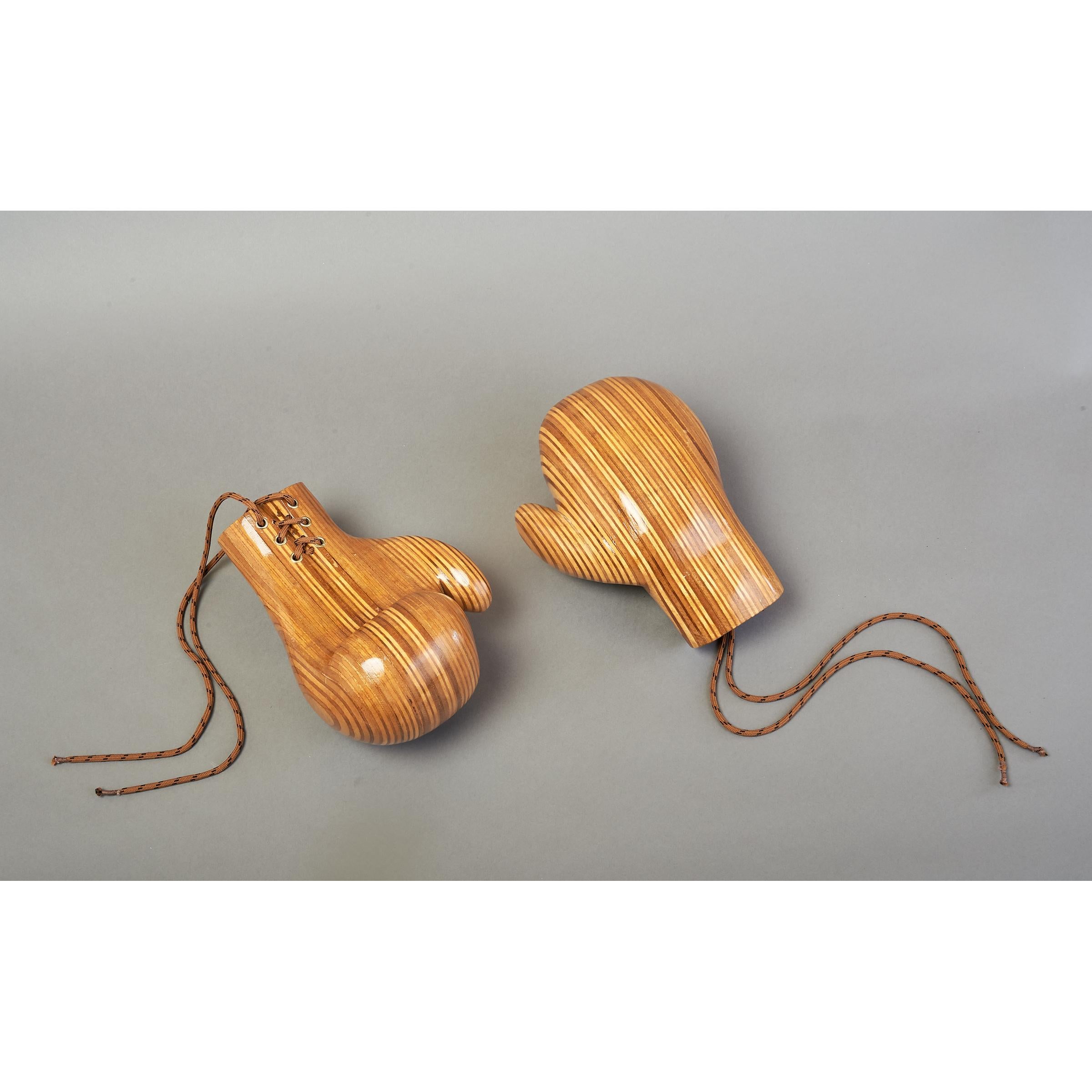 Pair of boxing gloves in a beautifully sculpted polished laminated wood.
Each glove: 10 W x 6 D x 6 H.
France, late 20th century.