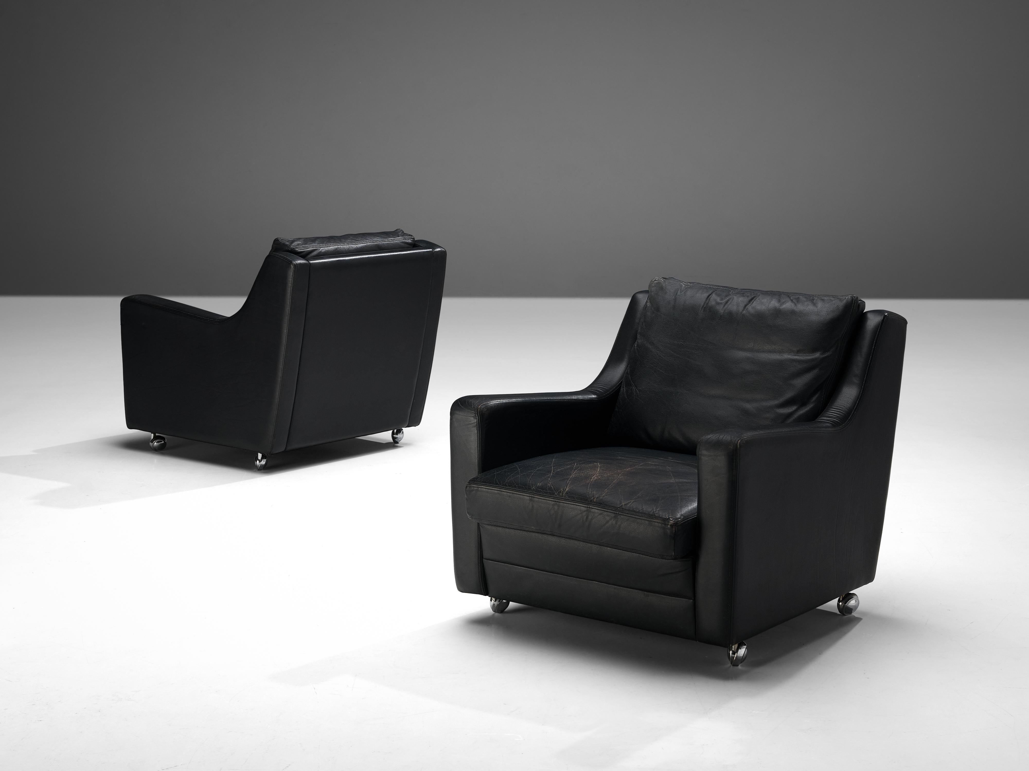 Pair of lounge chairs, black leather, steel, Europe, 1970s

The design of this stunning pair of lounge chairs features beautiful, clear lines, contributing to a sculptural appearance. The backrest smoothly runs over into the armrests creating an