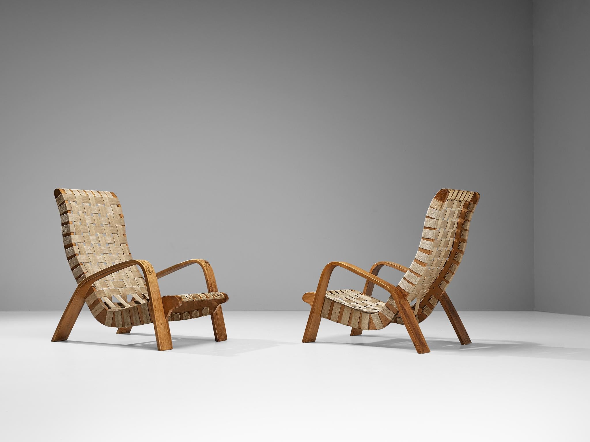 Pair of lounge chairs, beech, canvas, fabric, Czech Republic, 1950s

Sculpted lounge chairs made in the Czech Republic in the 1950s. These chairs are made in a slender beech frame, and are upholstered in canvas webbing. The straps are connected to
