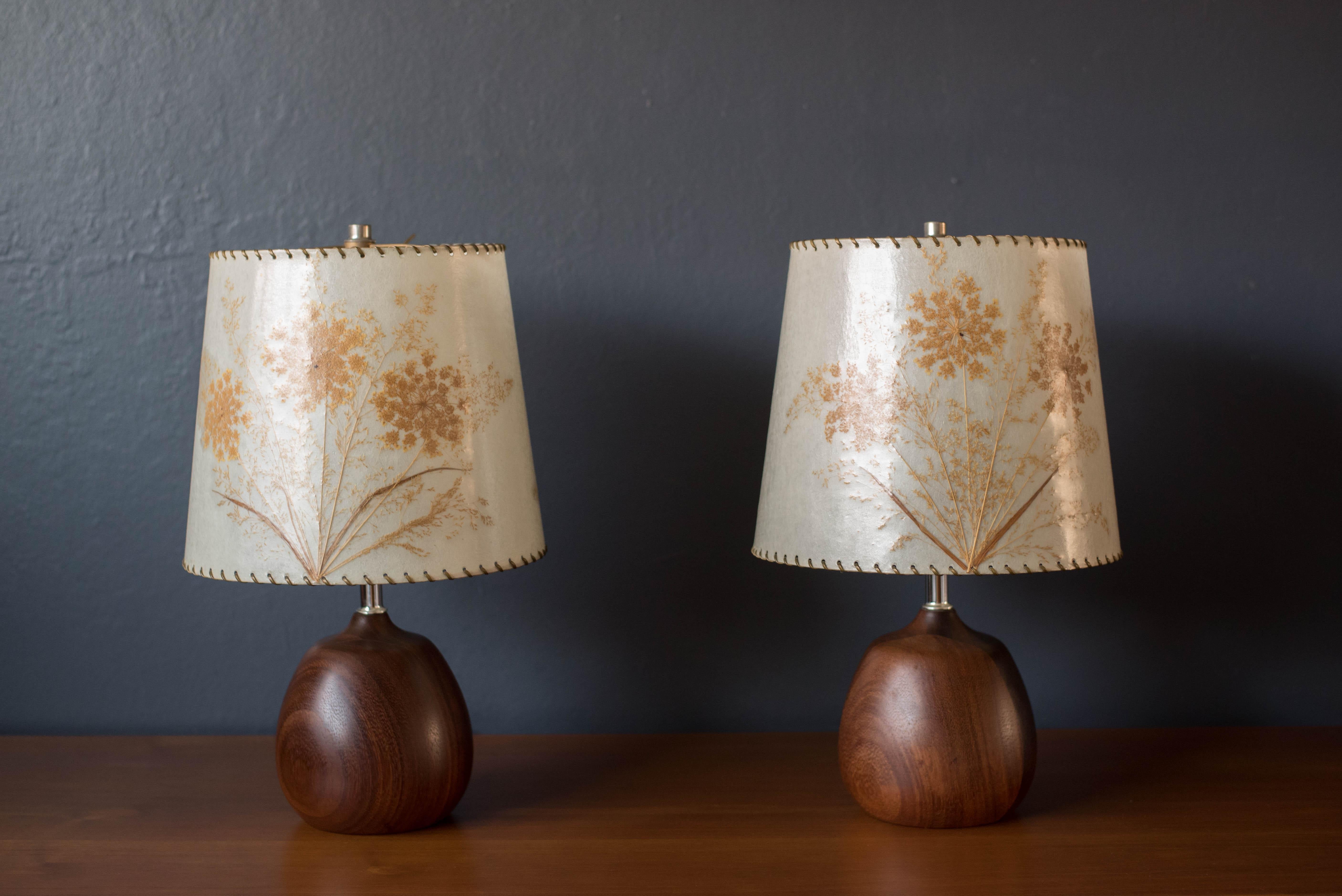 Vintage pair of Scandinavian Modern lamps circa 1960s. This unique set features a sculptural solid turned base in old growth teak accented with chrome hardware. Equipped with 3-way switch lighting. Shades are not included. Price is for the pair.