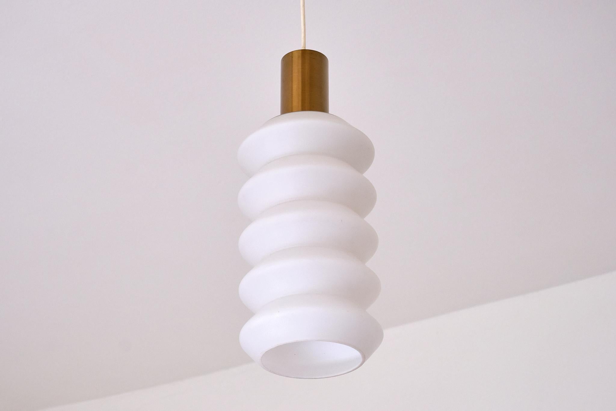 Questa rara coppia di lampade a sospensione scultoree è stata prodotta in Svezia negli anni Cinquanta.

Il design è definito dalla forma sorprendente del paralume in vetro opalino, con la sua forma a scaglie e i contorni lisci e arrotondati. Il