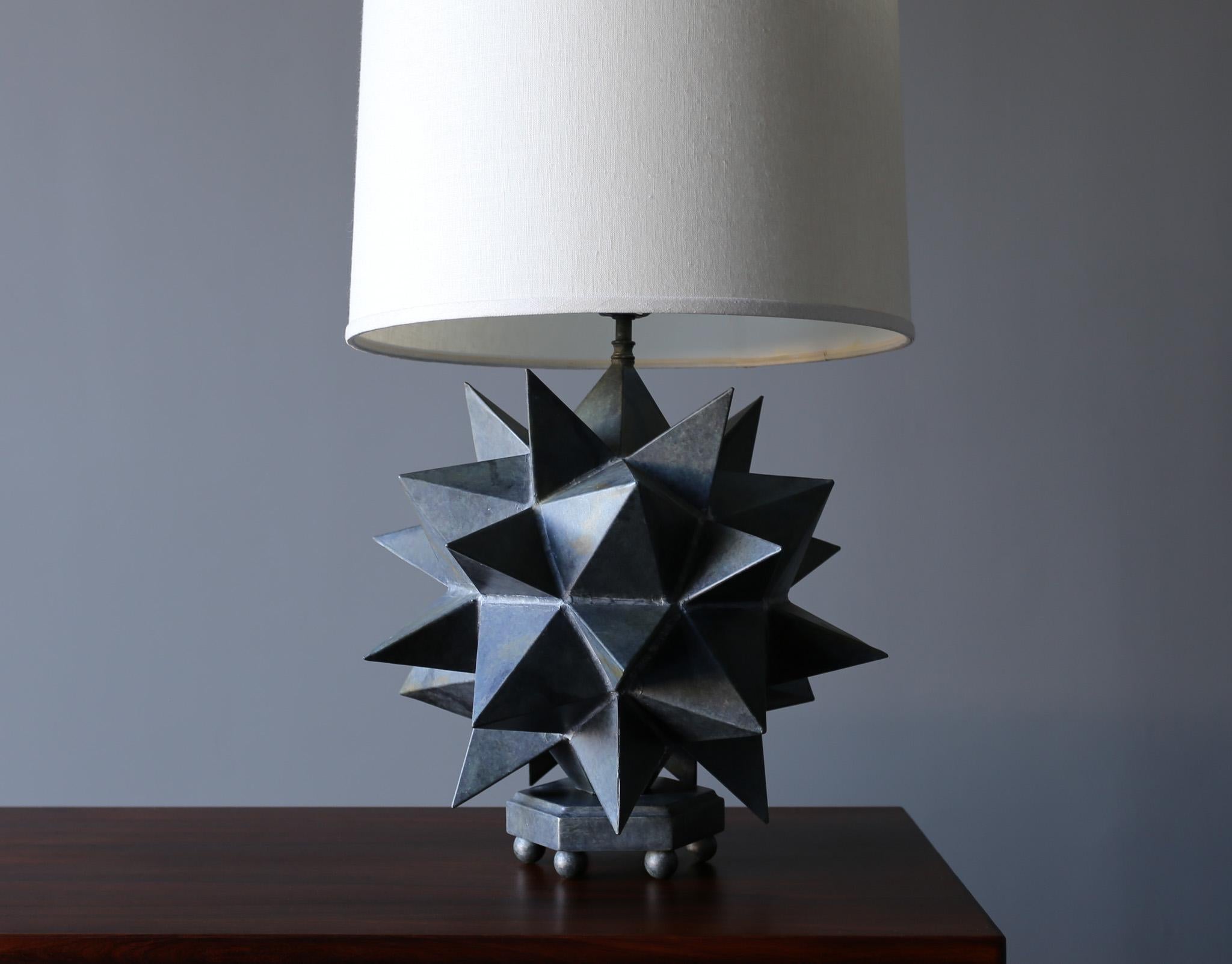Hand built sculptural star table lamp, circa 1975. Thin gauge patinated welded metal construction.

Measures: 
16