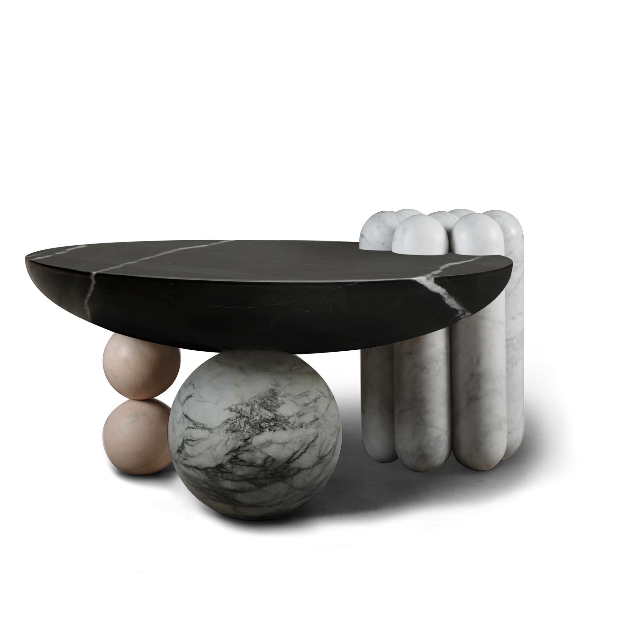 La table basse en marbre Patisserie est un ensemble de différentes formes inspirées de la pâtisserie - un pied latéral en forme de canelé et deux pieds en forme de bonbon soulèvent un plateau de table en forme de coupe pour un assemblage