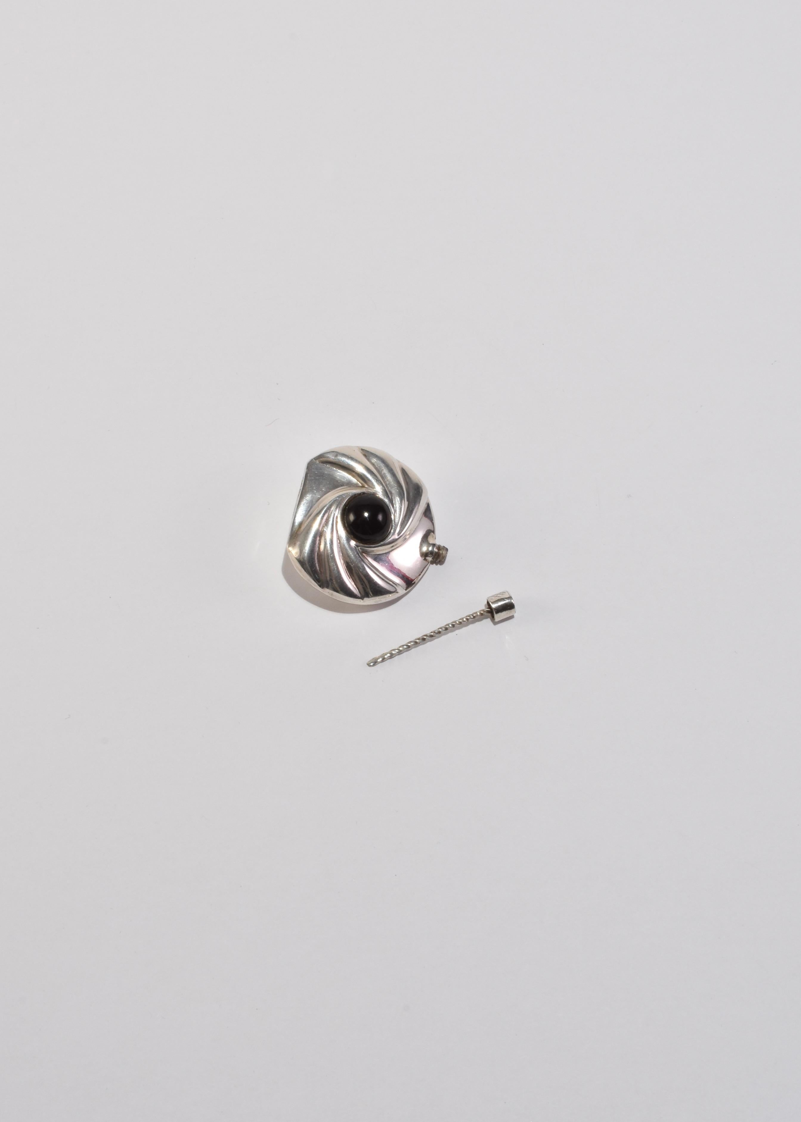 Ein skulpturaler Parfümflakon aus Sterlingsilber aus Taxco, Mexiko, etwa Mitte bis Ende des 20. Mit einem wirbelnden Repoussé-Motiv, das von einem gewölbten schwarzen Cabochon zentriert wird, und einem zierlichen Schraubverschluss. Bitte beachten