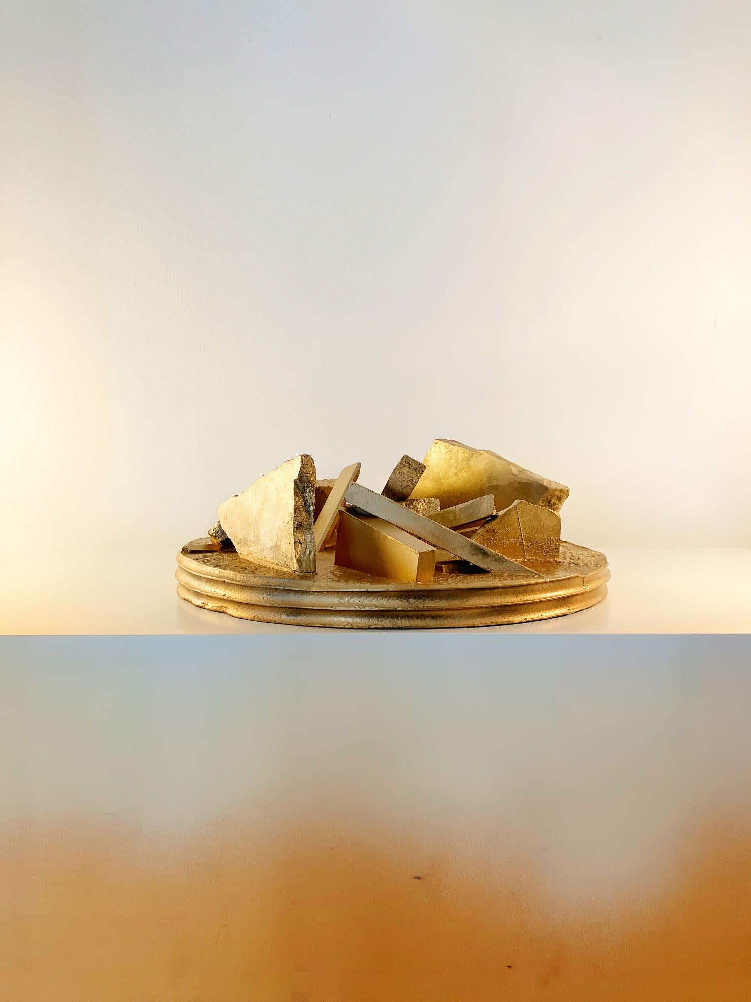 Pezzo scultoreo di Karystios
Dimensioni: D. 46 x H. 15 cm
Materiali: Calcestruzzo (con barre di rinforzo), marmo e detriti di pietra.

L'opera scultorea studia i detriti in una paradossale forma di cemento realizzata con i resti di pezzi di pietra e