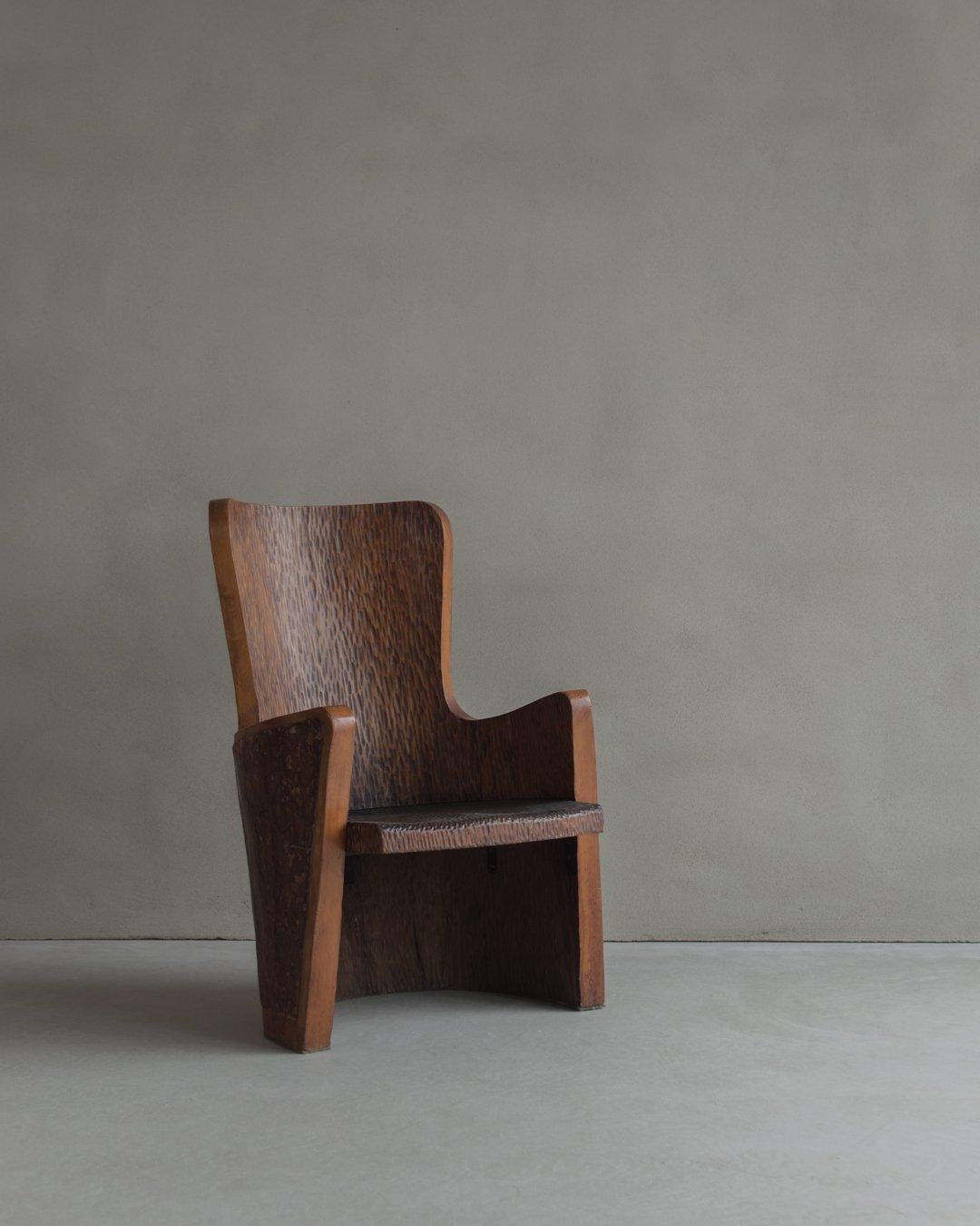 Dies ist ein einzigartiger Sessel aus dem 20. Jahrhundert, der fachmännisch von Hand aus Kiefernholz geschnitzt wurde und dessen Rückenlehne mit Naturrinde verziert ist. Dieser bezaubernde Sessel ist ein wahres Zeugnis für das Können und die