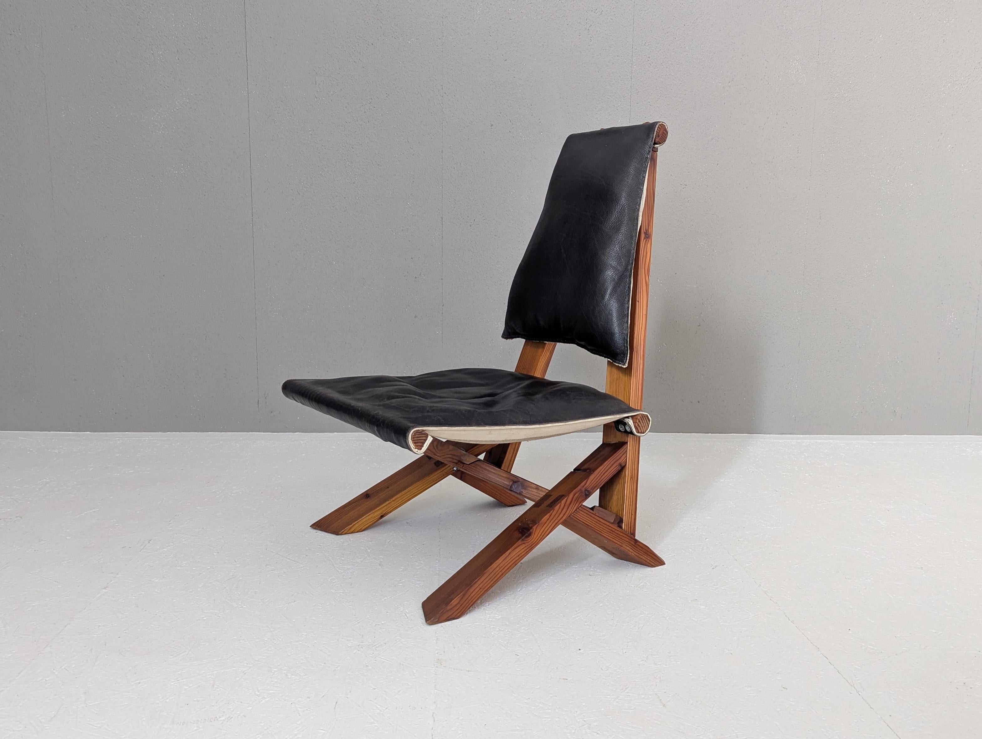 Questa straordinaria poltrona in legno di pino è chiaramente ispirata all'iconico modello Dromadaire di Pierre Chapo, ma la sua costruzione e le sue proporzioni fanno pensare a una rara interpretazione realizzata in studio negli anni Settanta. Con