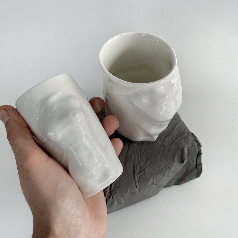 A set of 2 sculptural porcelain cups handmade by the ceramic artist Hulya Sozer. 
Food safe glaze.
Dishwasher safe.

Female Cup
Height: 9cm / Depth: 7cm / Diameter: 6cm
Volume: 100ml

Male Cup
Height: 9cm / Depth: 8cm / Diameter: 6cm
Volume: