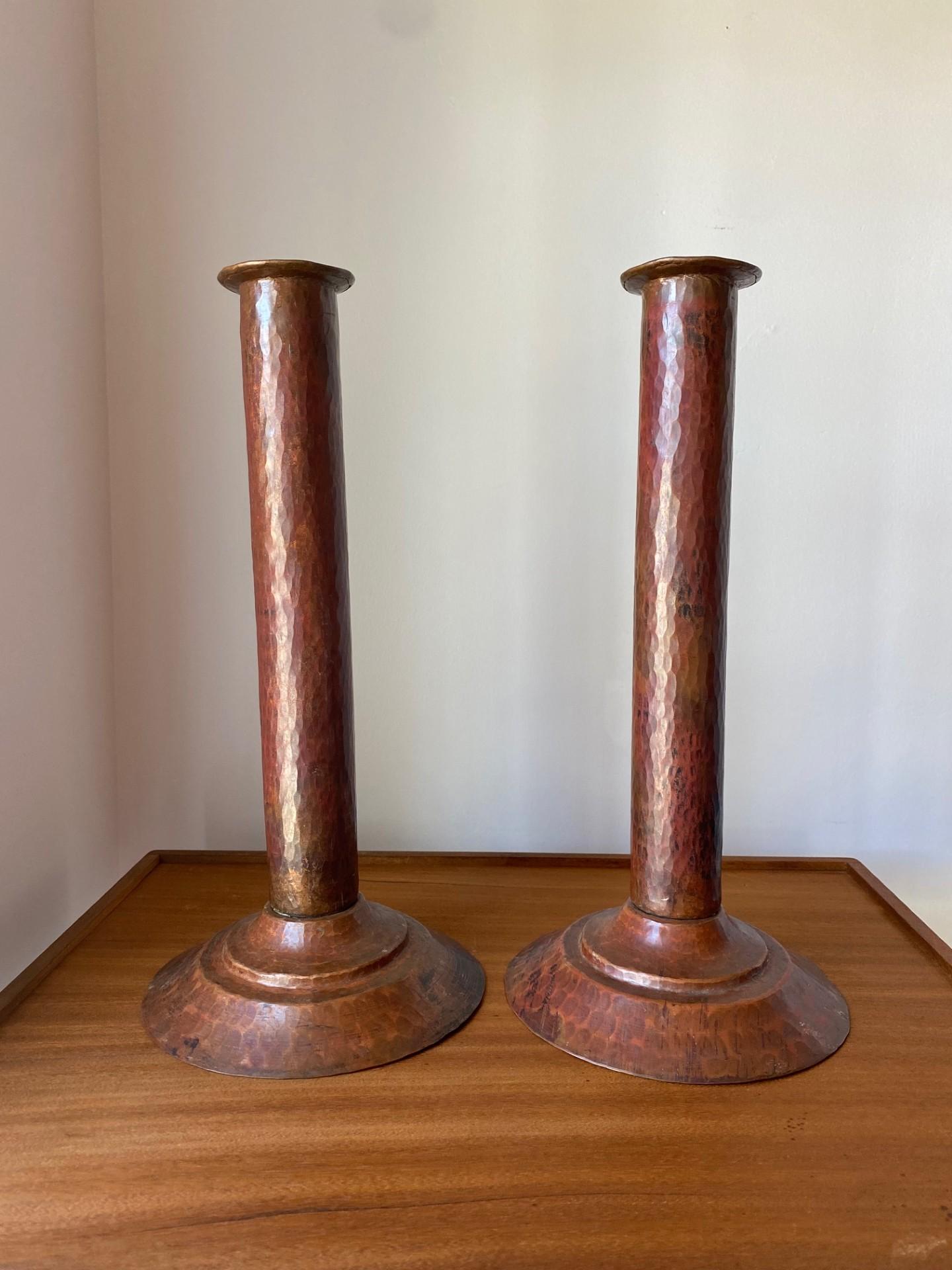 Beautiful and sculptural pair of hammered copper candleholders.  This pair is fully realized in quality copper that enhances the beauty and form of each candleholder.  The simple lines concocted in each one are minimal yet exquisite in the subtle