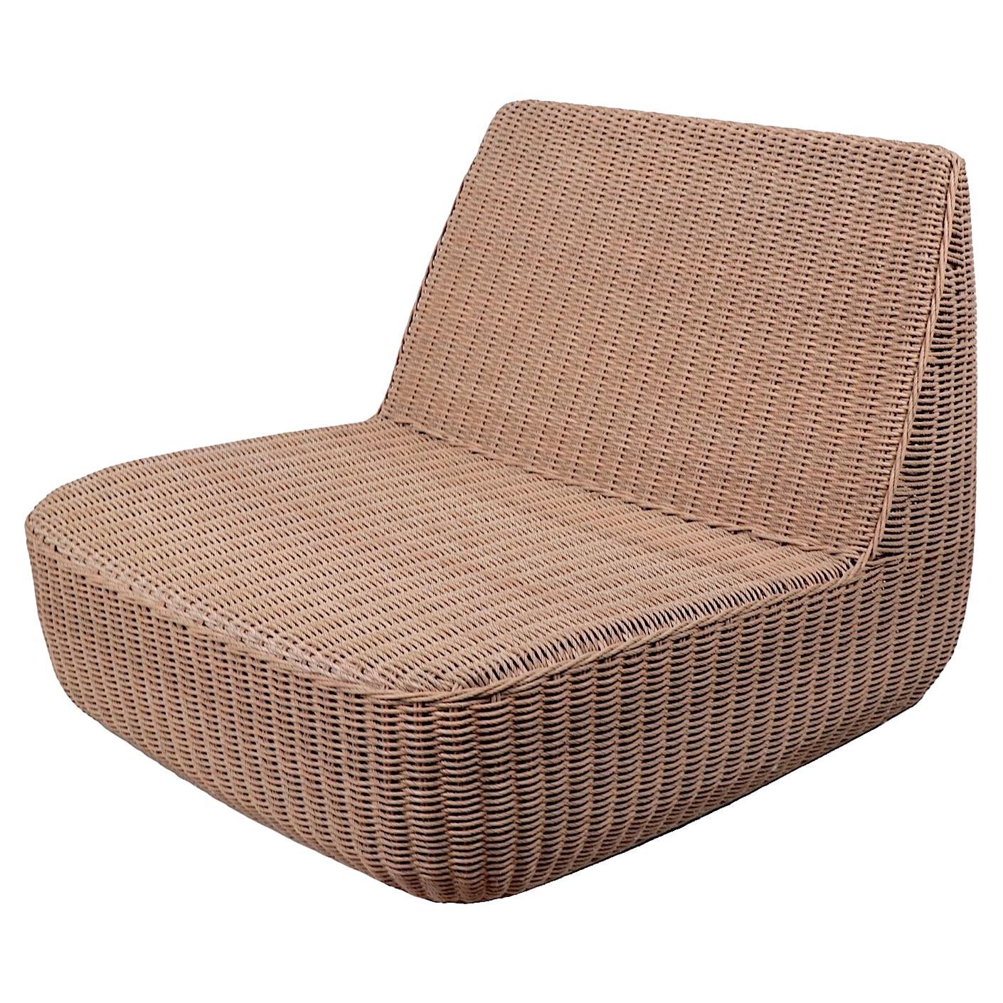 Chic, stylish and sophisticated low slung wicker lounge chair designed by Mark Gabbertas, for Gloster as part of the classic Omaha series. The chair is constructed of a wicker shell, over a metal structure. The wicker is treated which allows for