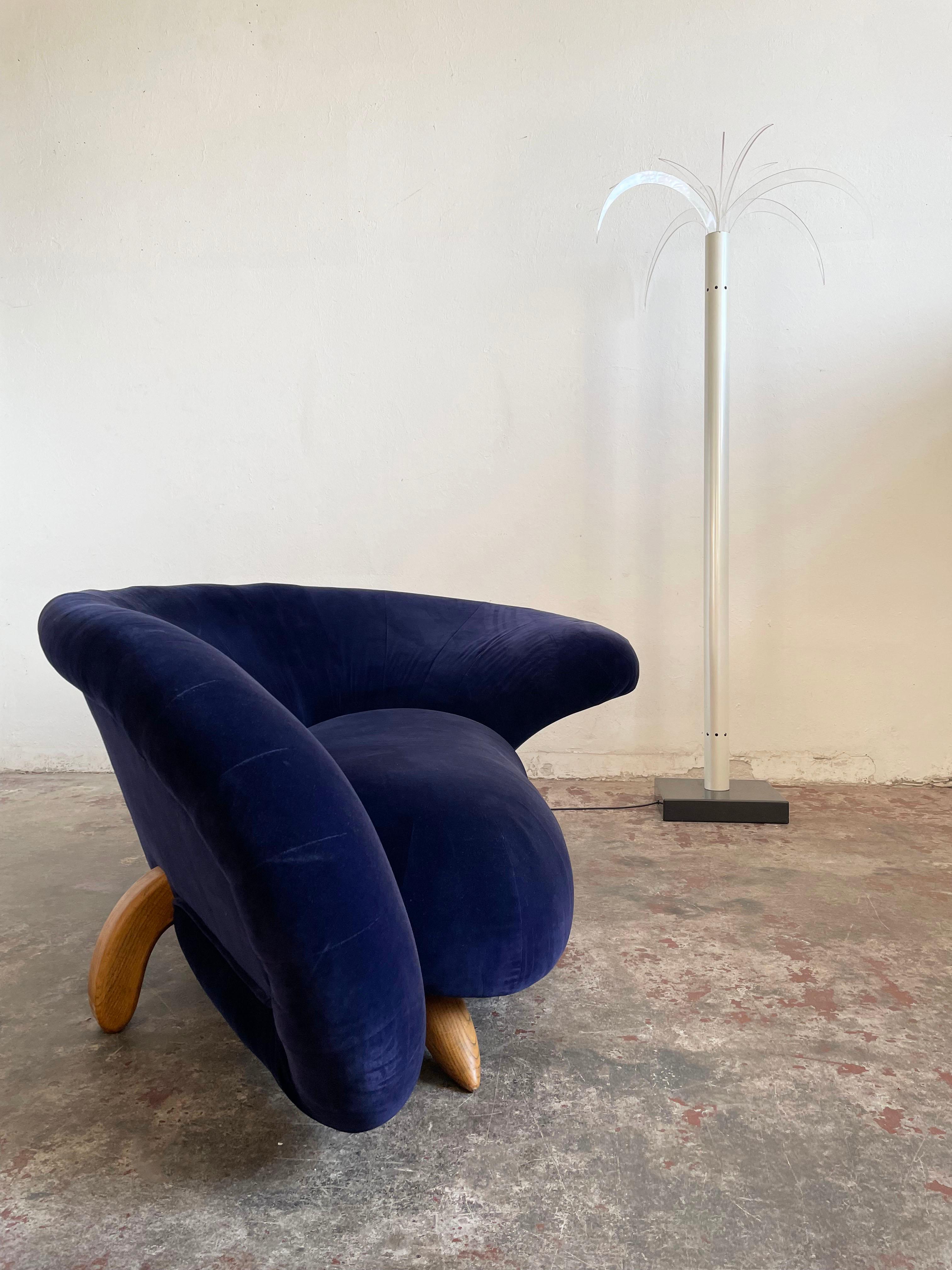 Vintage sculptural postmodern loveseat from the 1980s/1990s upholstered in blue velvet-like fabric.

It has an asymmetrical rounded curved form, original upholstery in beautiful deep blue color, and wooden legs.

Size: 76 x 204 x 122 cm (H/W/D),