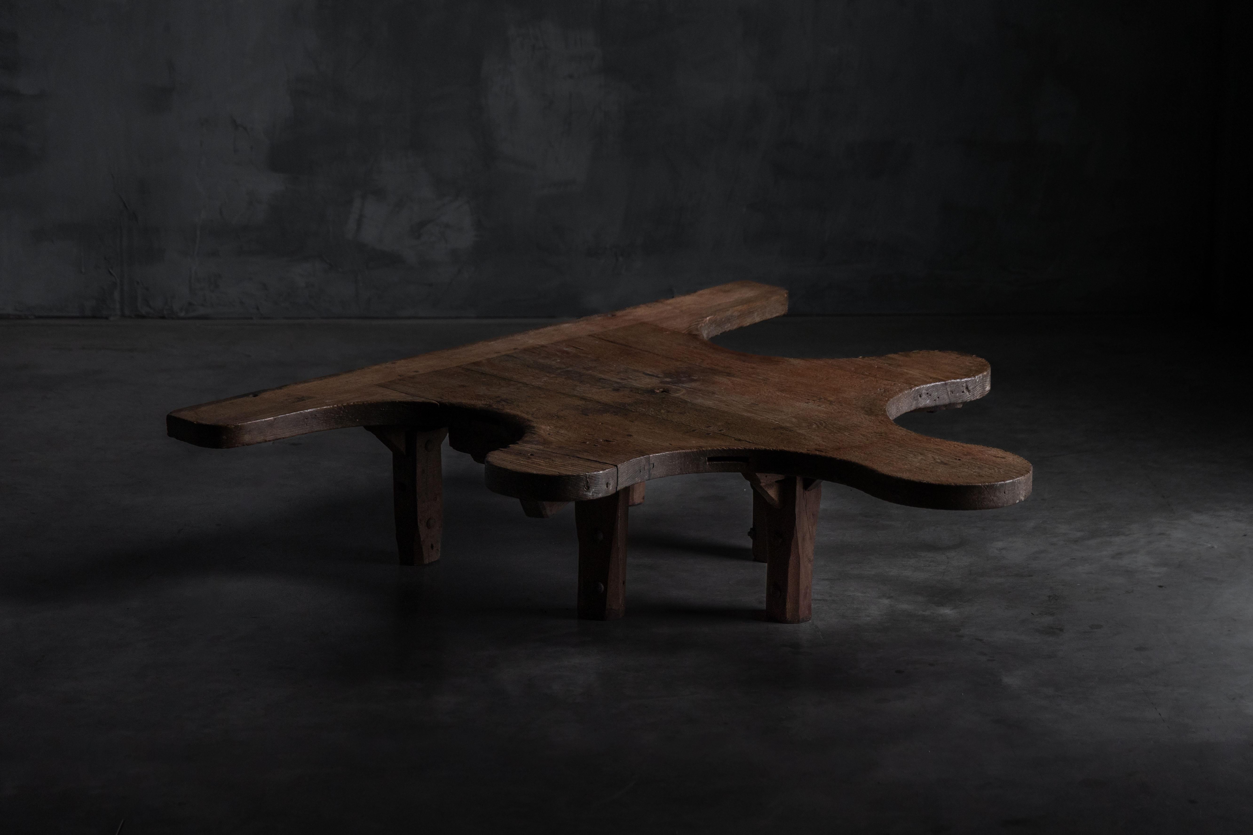 Autrefois surface de confiance de l'établi d'un bijoutier, cette table étonnante a été réimaginée comme une table basse sculpturale - conservant chaque marque, courbe et coupe de son passé industriel. La silhouette organique, façonnée par des années