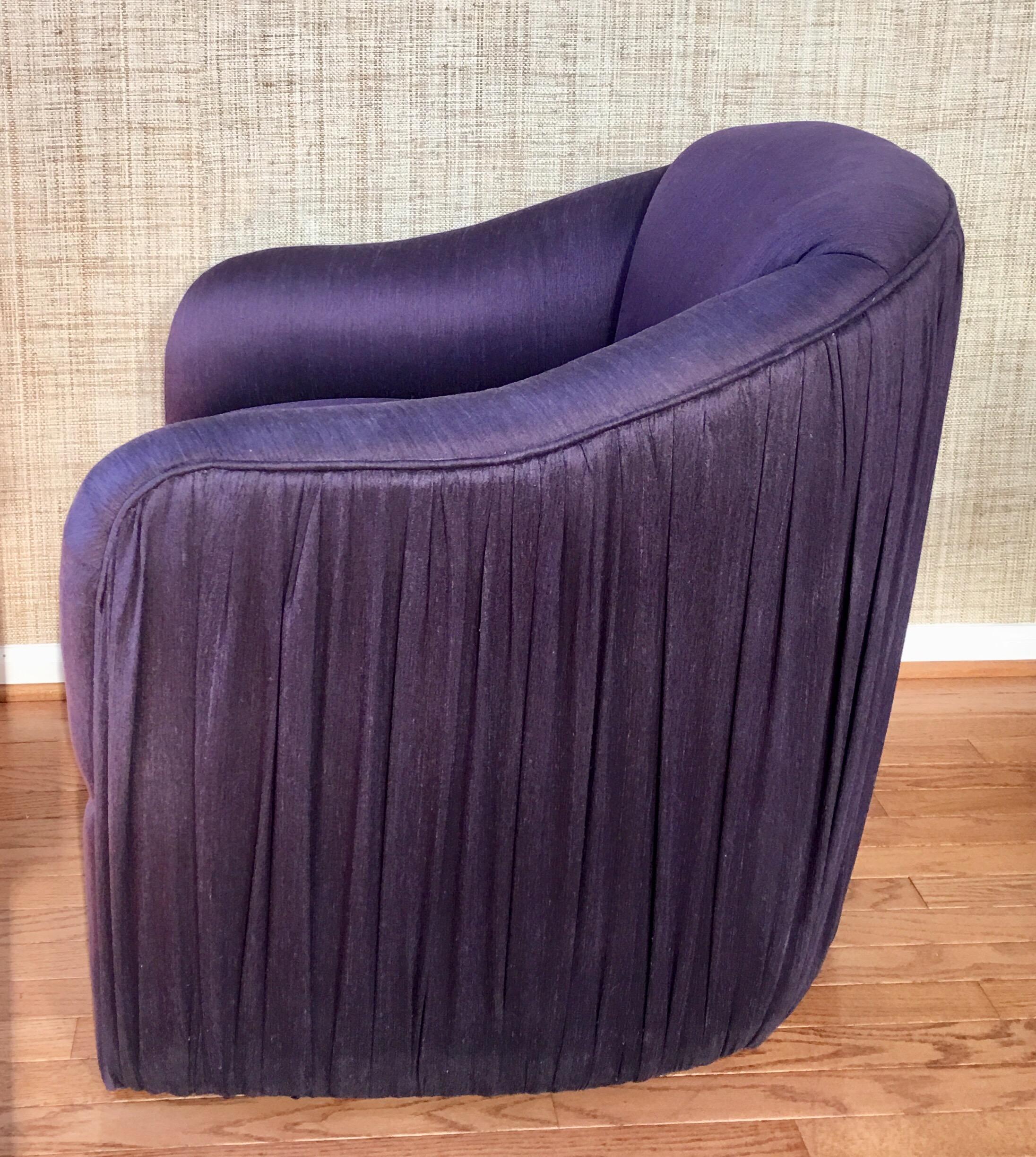 Unique and sculptural lounge chair with matching round soufflé pouf ottoman featuring original aubergine or purple toned fabric. Design details of this custom seating set includes ruched or pleated fabric on outside back/sides of chair and on the