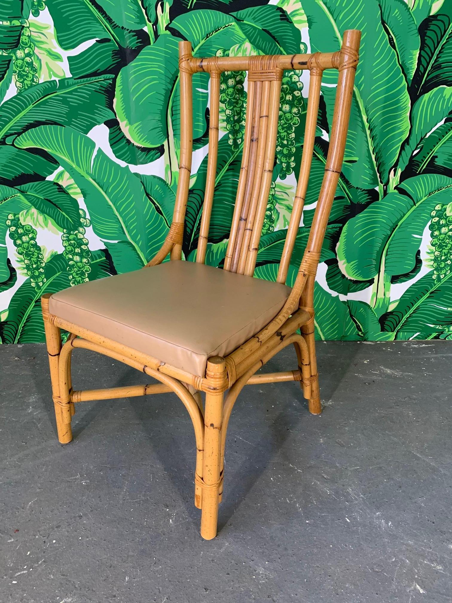 Set of 6 rattan dining chairs with sculptural form. Vinyl seat cushions that could easily be recovered. Very good vintage condition with minor imperfections consistent with age.