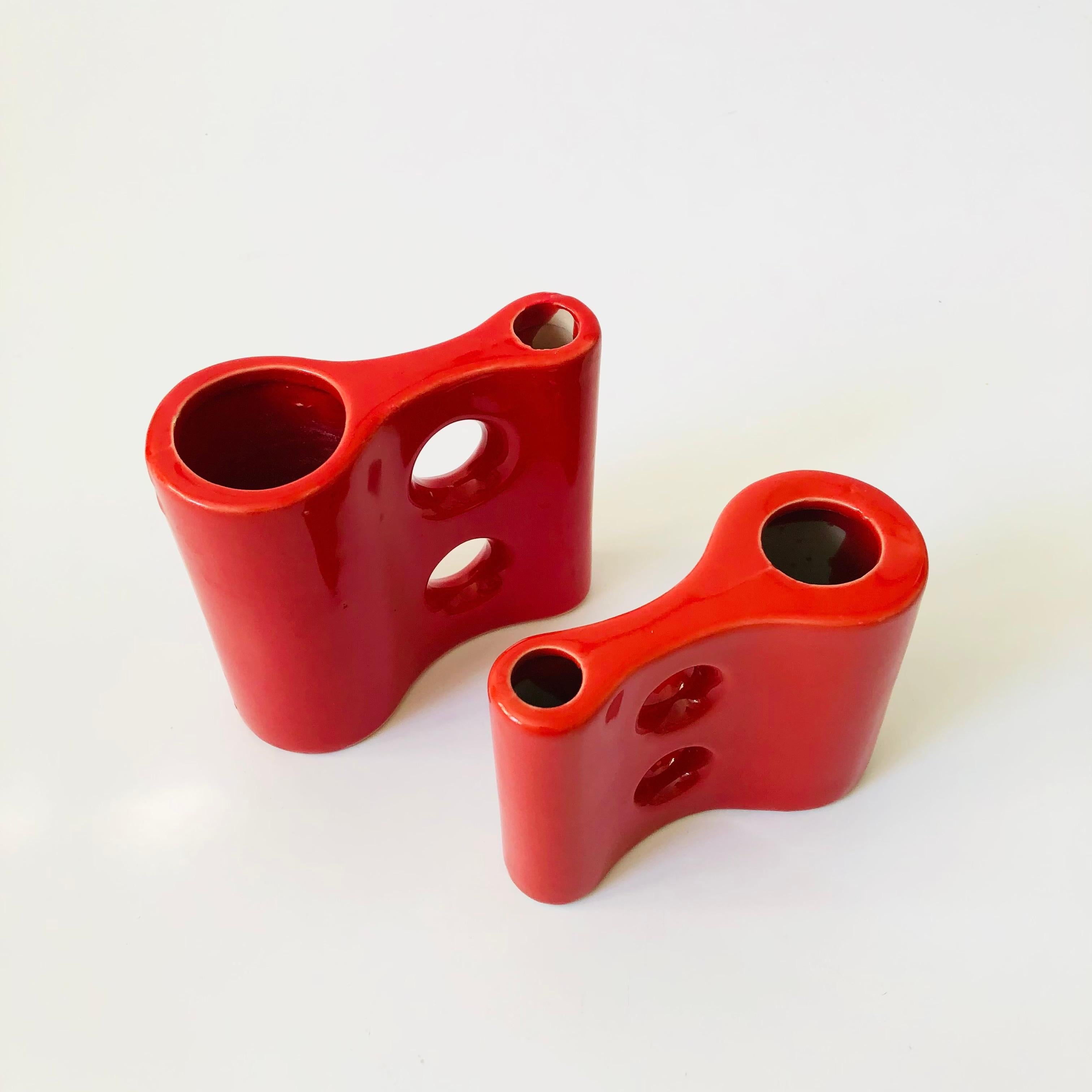 A pair of vintage sculptural ceramic vases in varying sizes. Unique shapes with holes on one side and two openings for holding flowers. Finished in a vibrant red glaze.
Measurements:
4.25