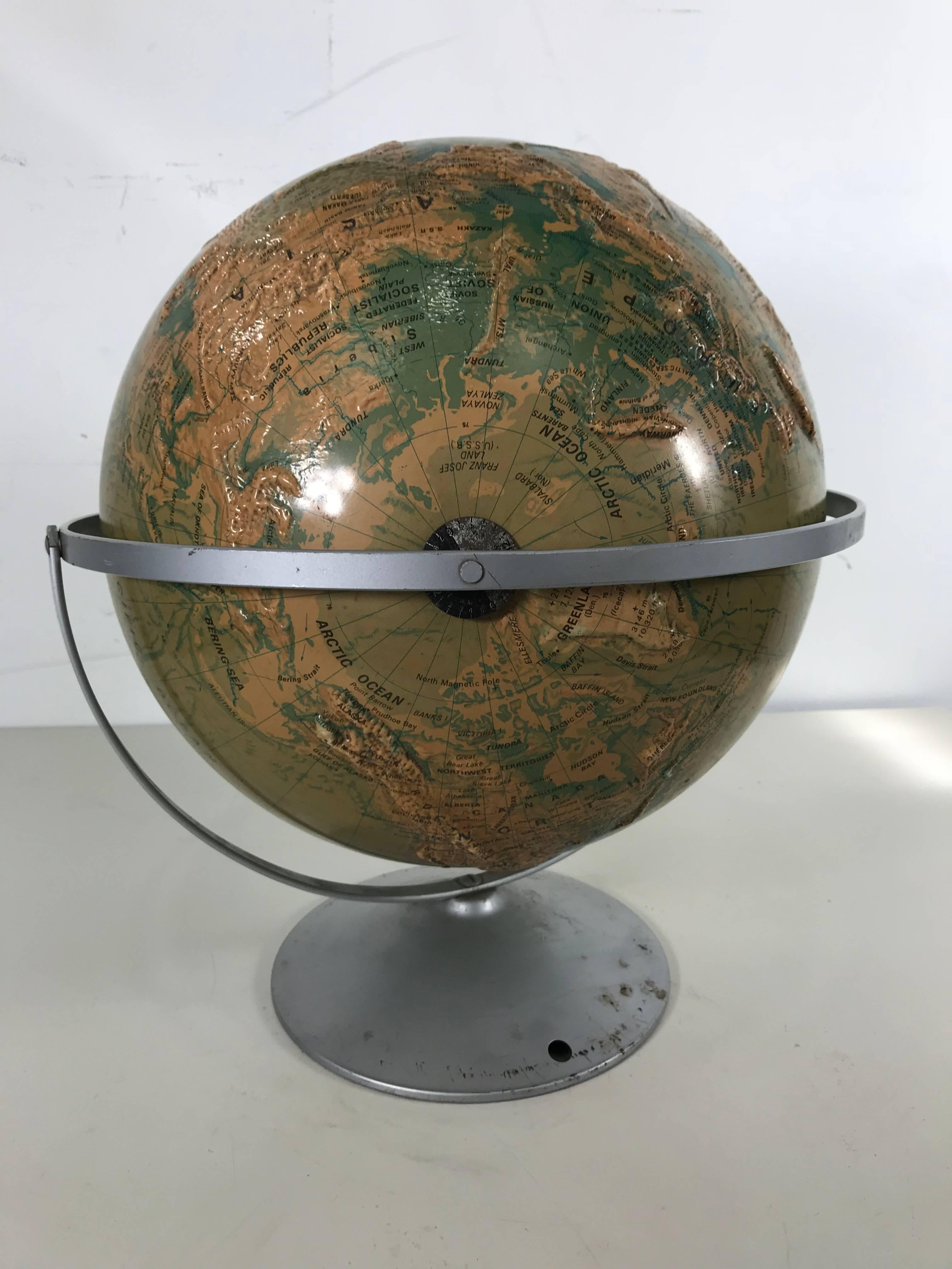 Sculptural relief world globe by Nystrom, wonderful design, aluminum stand, raised graphics, nice color and patina. Measures: 16