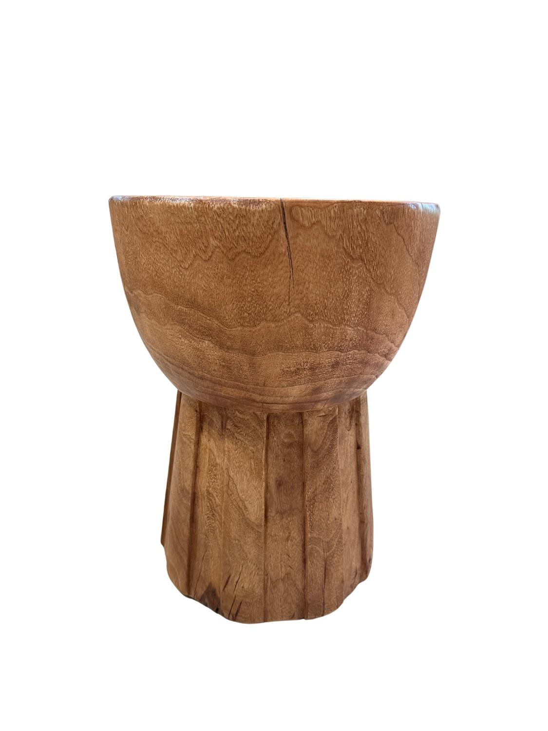 Hecha a mano a partir de una pieza maciza de madera de alcanfor, esta mesa auxiliar muestra asombrosos patrones de veteado y tonos ricos y cálidos. La superficie superior presenta anillos de crecimiento bellamente conservados, que añaden un toque de