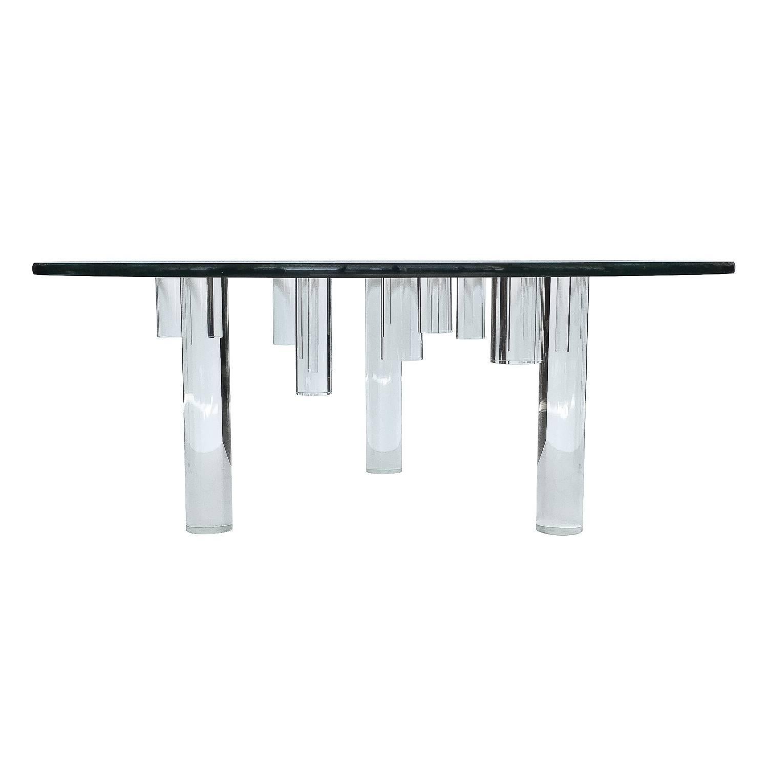 Unique sculptural Lucite coffee table with round glass top. This table features three clear Lucite cylinder legs and ten clear Lucite cylinders in various lengths that are all fused to the glass top. They hang like stalagmites from the underside of