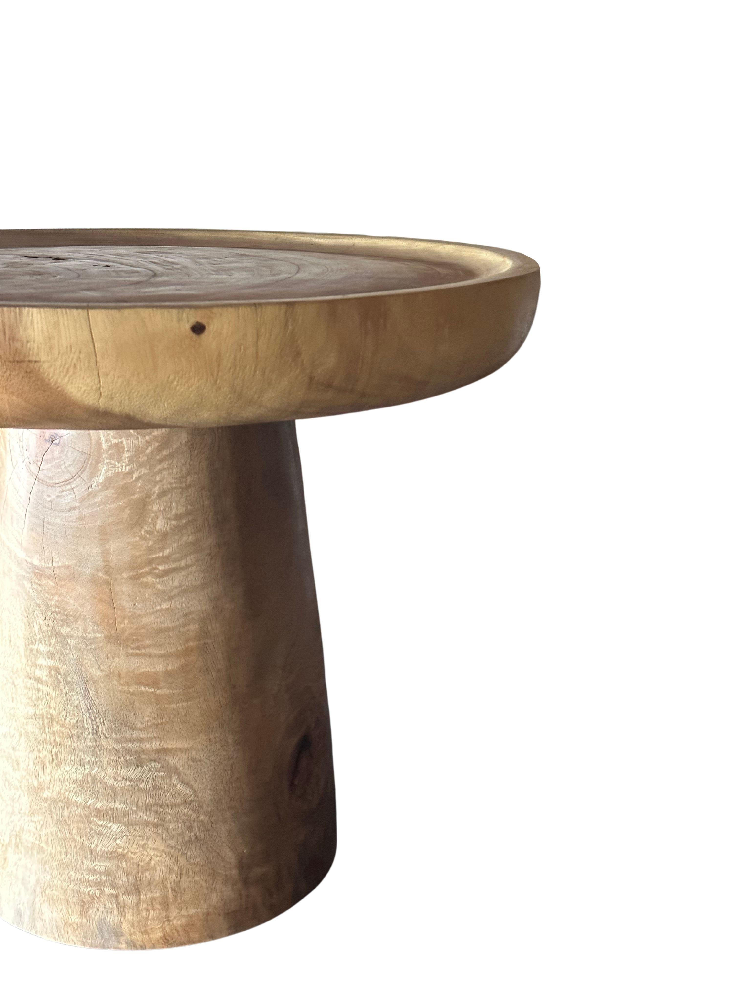 Dieser wunderbar skulpturale runde Beistelltisch verfügt über eine Tischplatte mit einem flachen Becken und einem umlaufenden Rand. Die neutrale Farbgebung des Tisches macht ihn perfekt für jeden Raum. Er wurde aus einem massiven Block Mangoholz