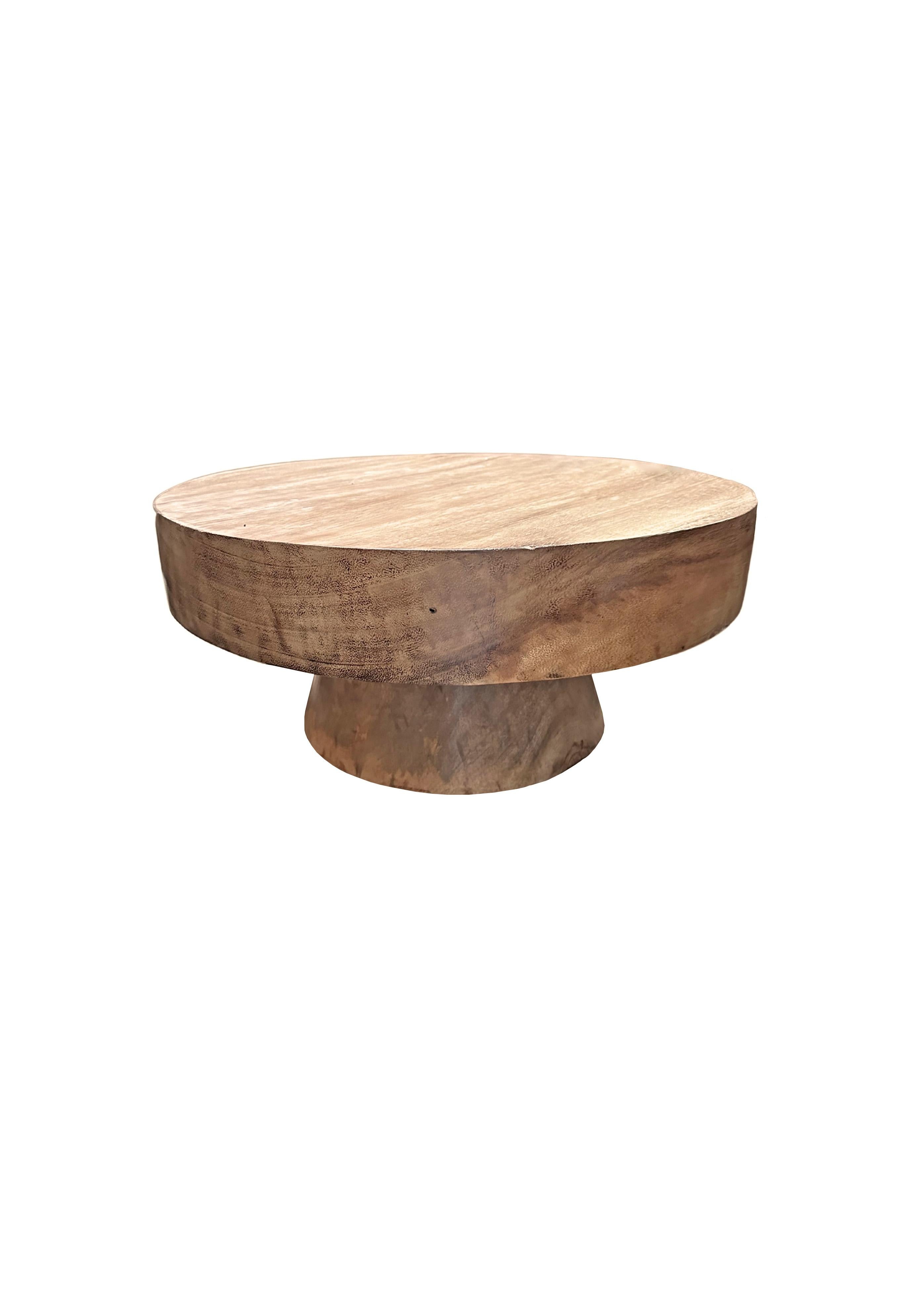 A wonderfully sculptural round side table featuring a natural finish. Its neutral pigment and subtle wood texture makes it perfect for any space. This table was crafted from mango wood and has a smooth texture. 

 