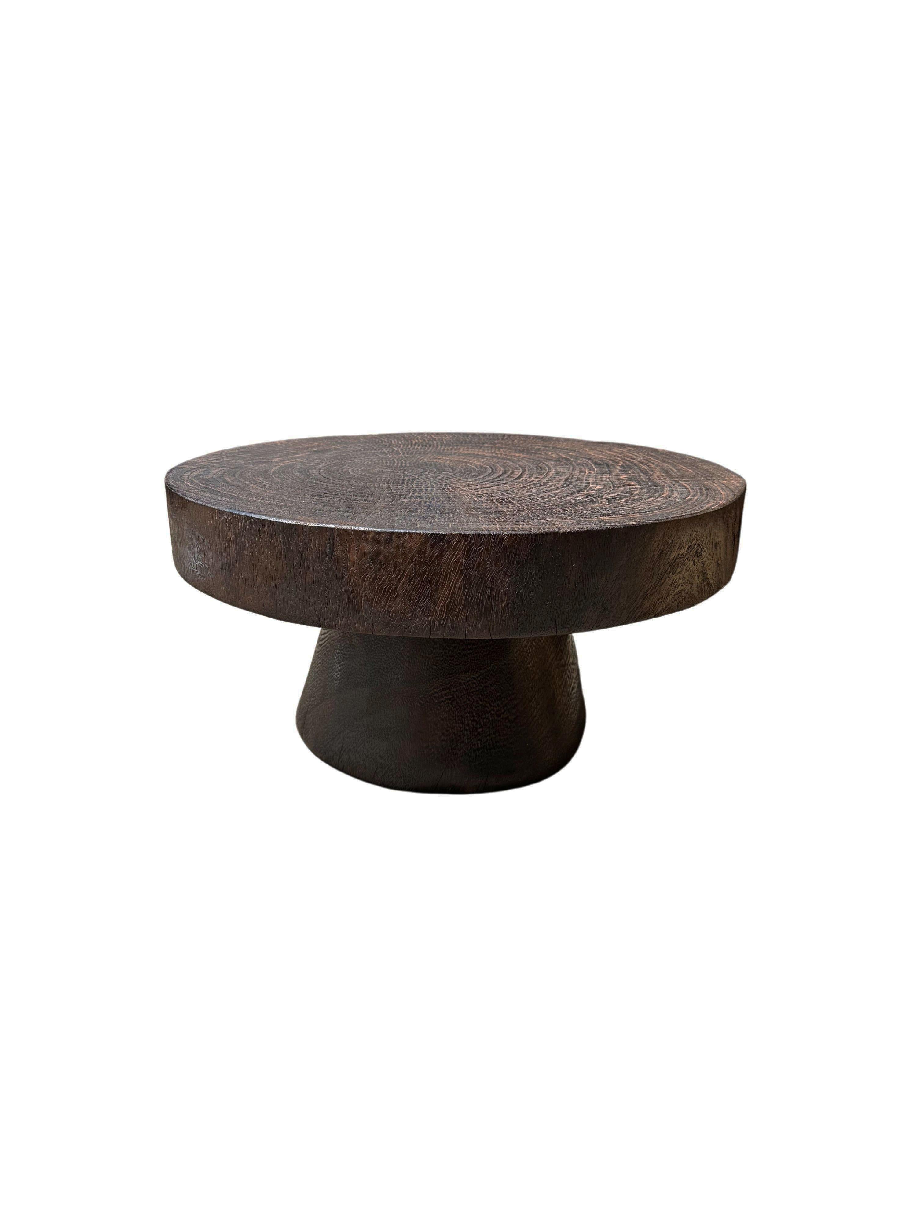 Une table d'appoint ronde merveilleusement sculpturale dotée d'une finition naturelle. Son pigment neutre et sa texture boisée subtile s'intègrent parfaitement à tous les espaces. Une pièce sculpturale unique et polyvalente qui ne manquera pas de