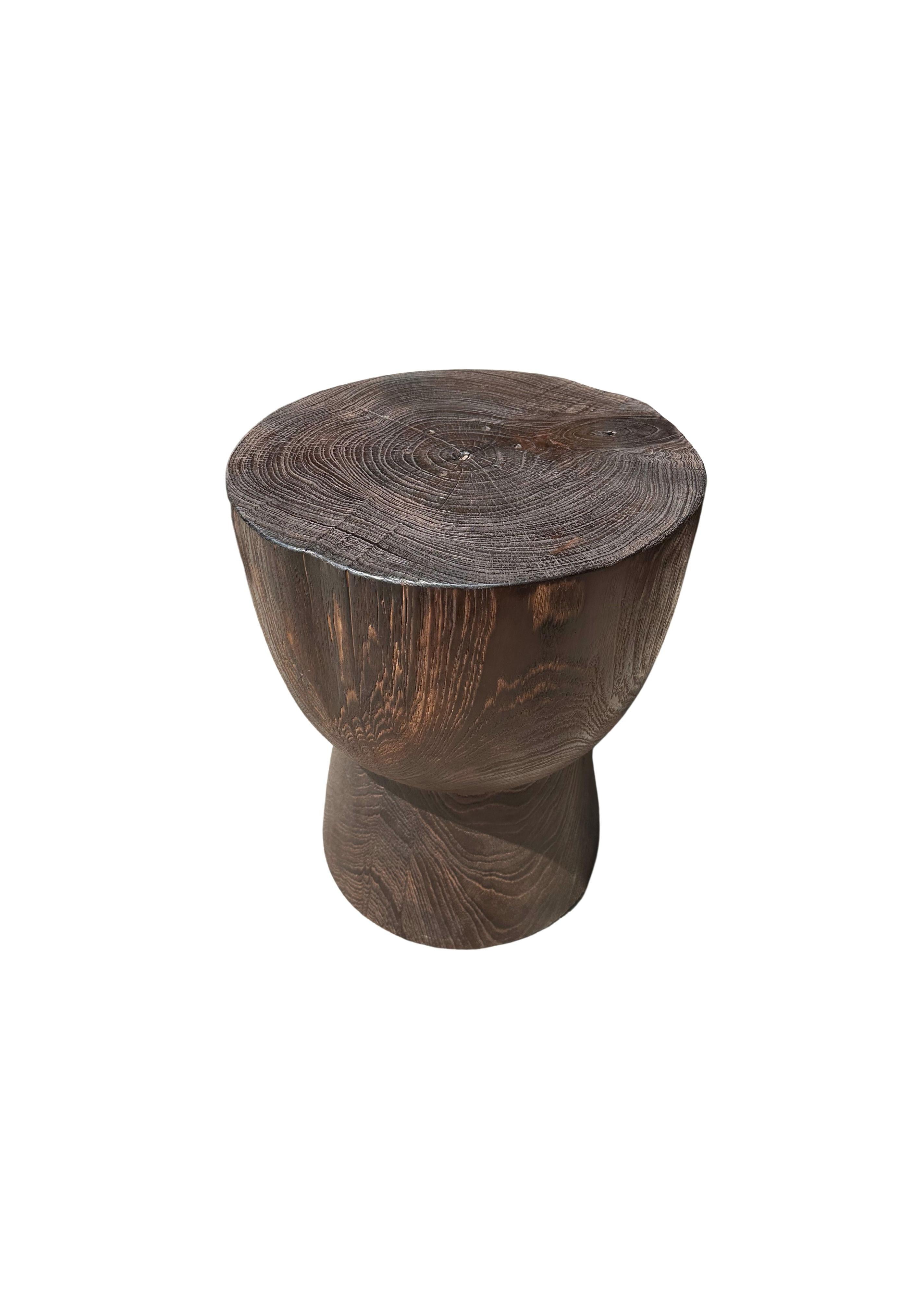 A wonderfully sculptural round side table featuring a natural finish. Its neutral pigment and subtle wood texture makes it perfect for any space. A uniquely sculptural and versatile piece certain to invoke conversation. This table was crafted from