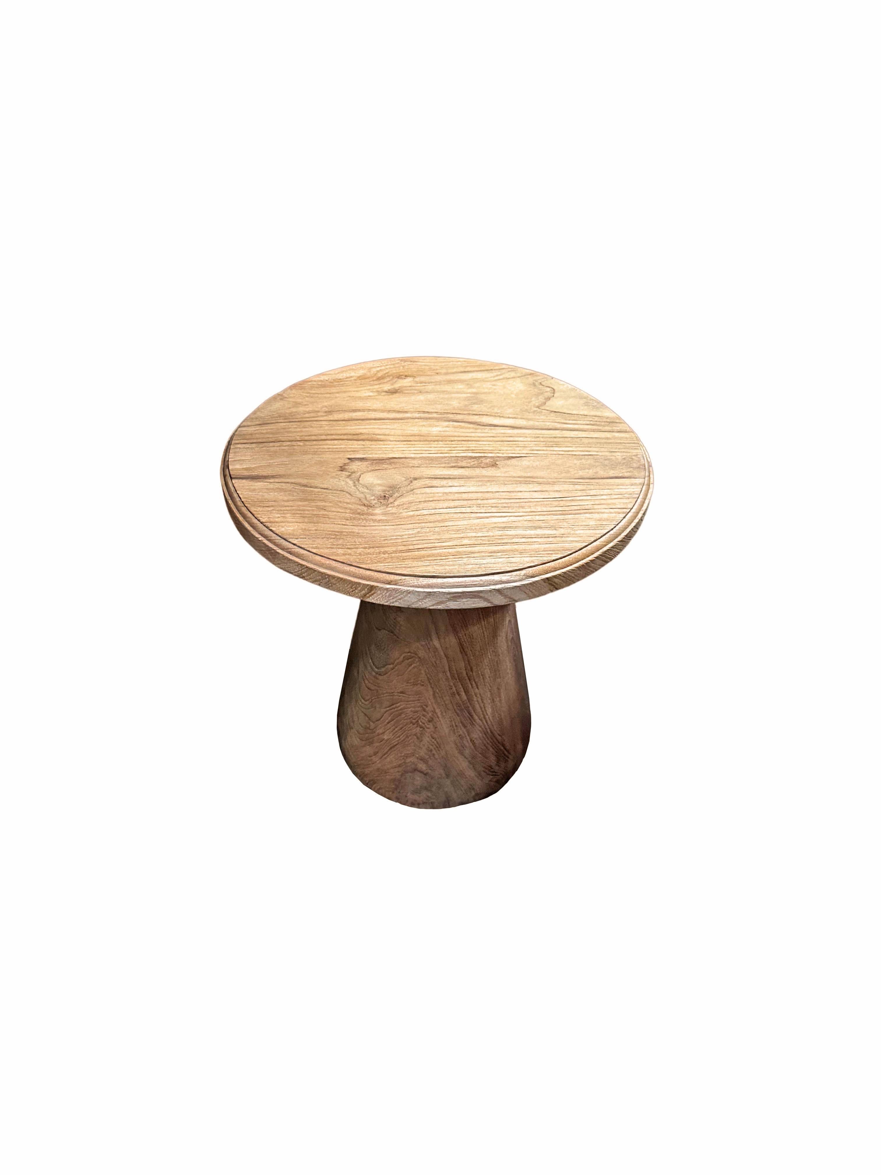 A wonderfully sculptural round side table featuring a natural finish. Its neutral pigment and subtle wood texture makes it perfect for any space. This table was crafted from teak wood and has a smooth texture. 

 