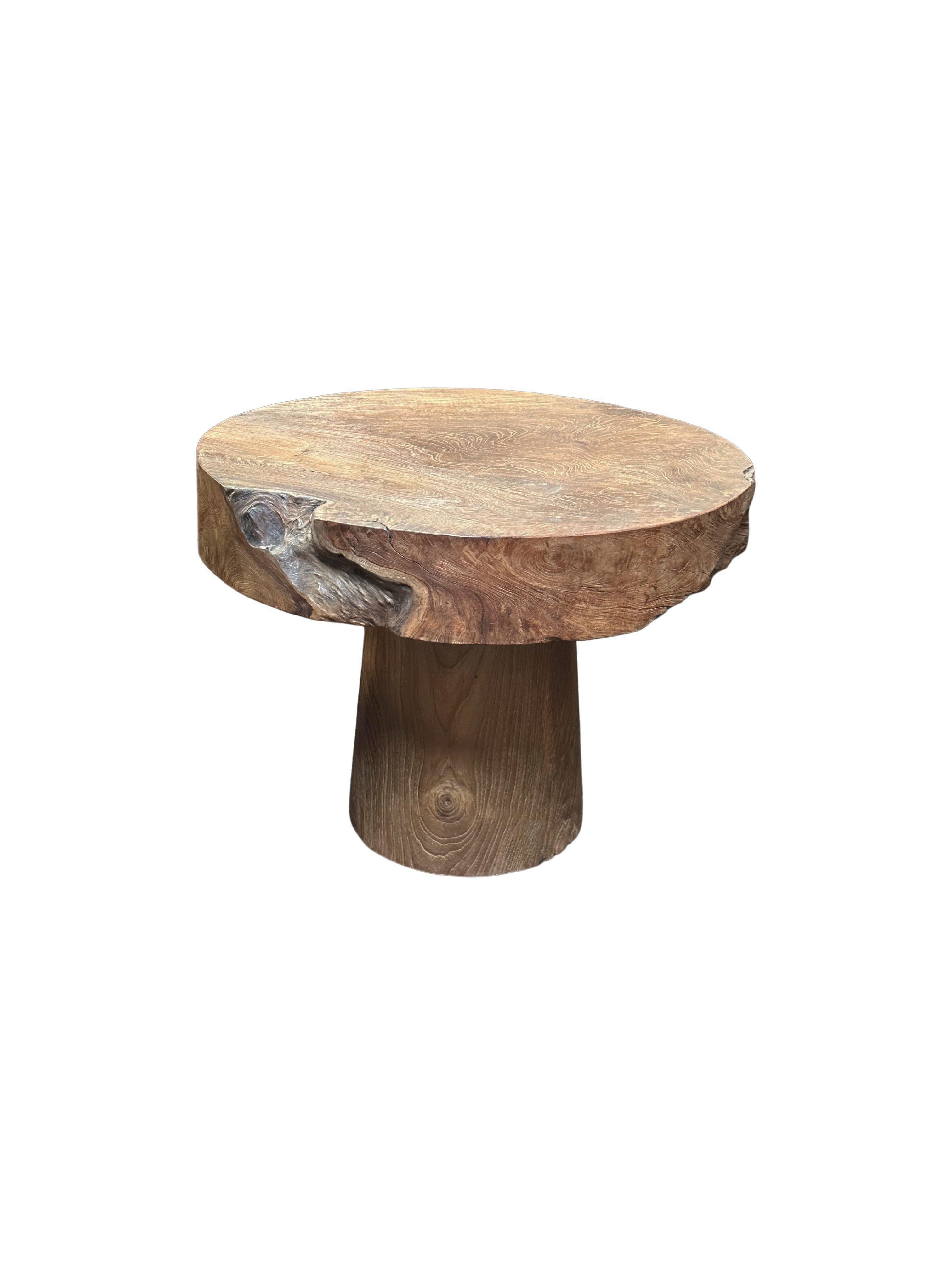 A wonderfully sculptural round side table featuring a natural finish. Its neutral pigment and wood textures add to its charm. This table was crafted from teak wood. 

The images are of a sample table and each custom item although maintaining the