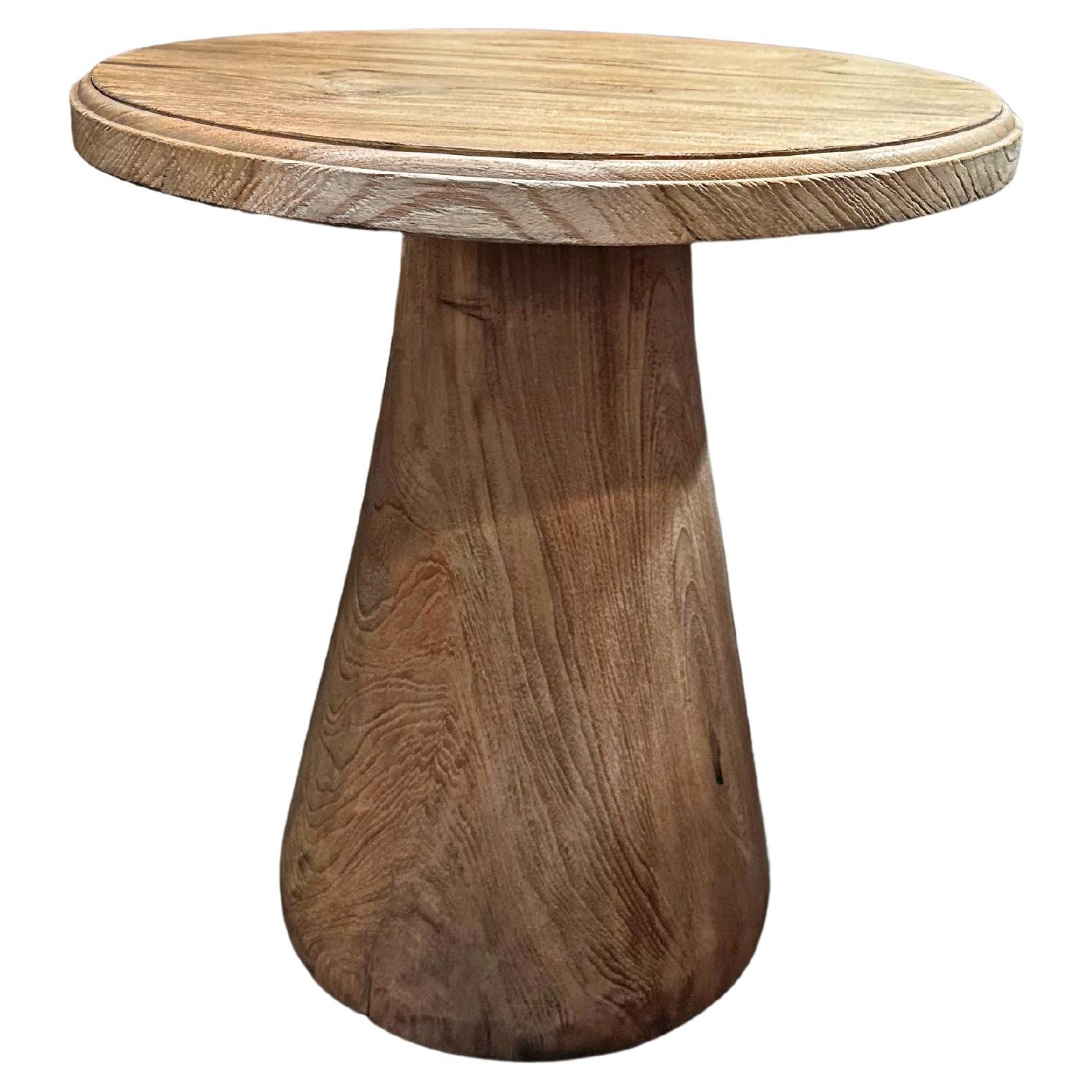 Table ronde sculpturale fabriquée en bois de teck, finition naturelle