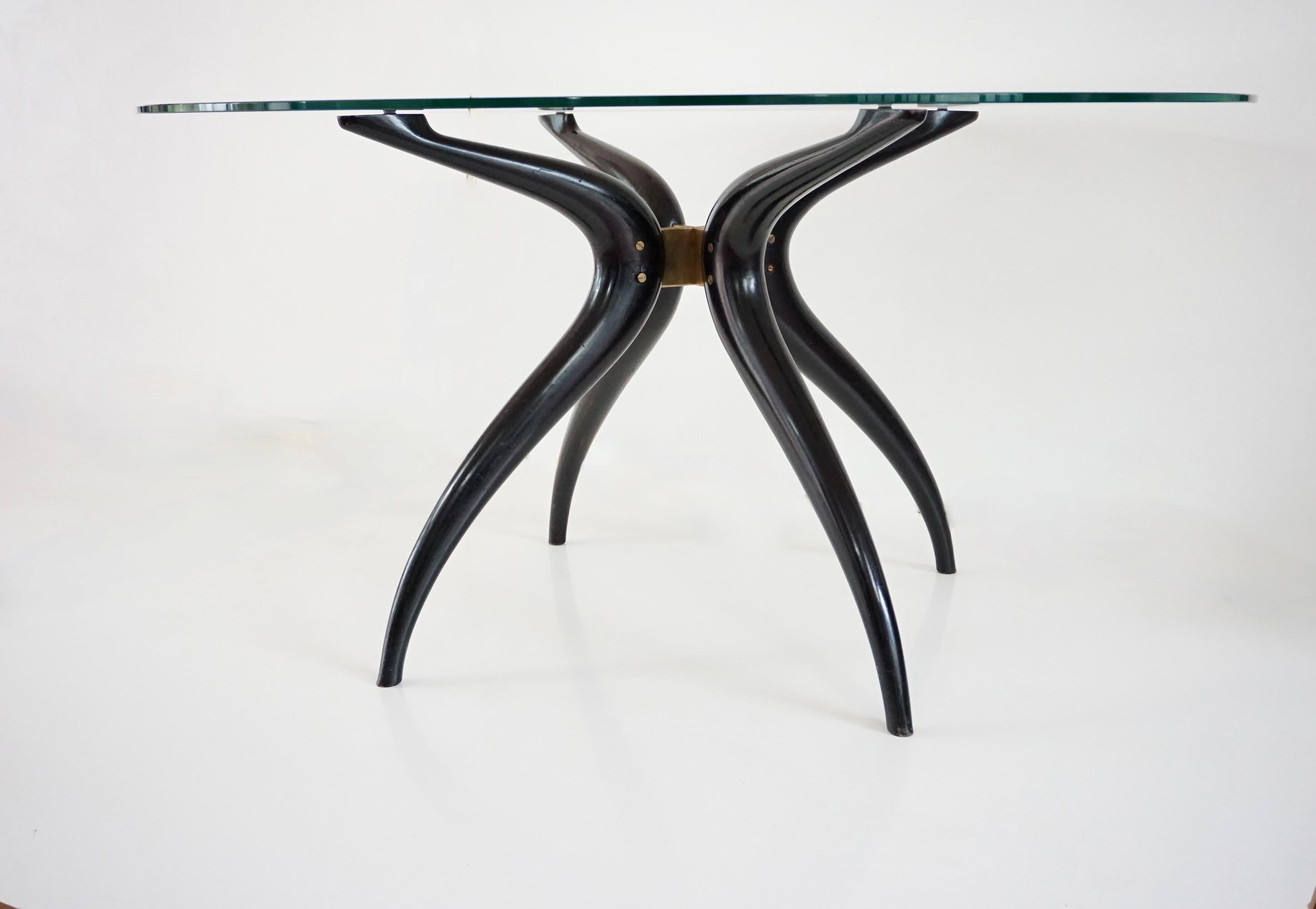 Table ronde sculpturale, table de salle à manger ou table centrale
adepte de Carlo Mollino vers 1945
hêtre sculpté et peint, détails en laiton et plateau en verre
sculpture en bronze en forme de croix servant de support à la table ; quatre pieds en