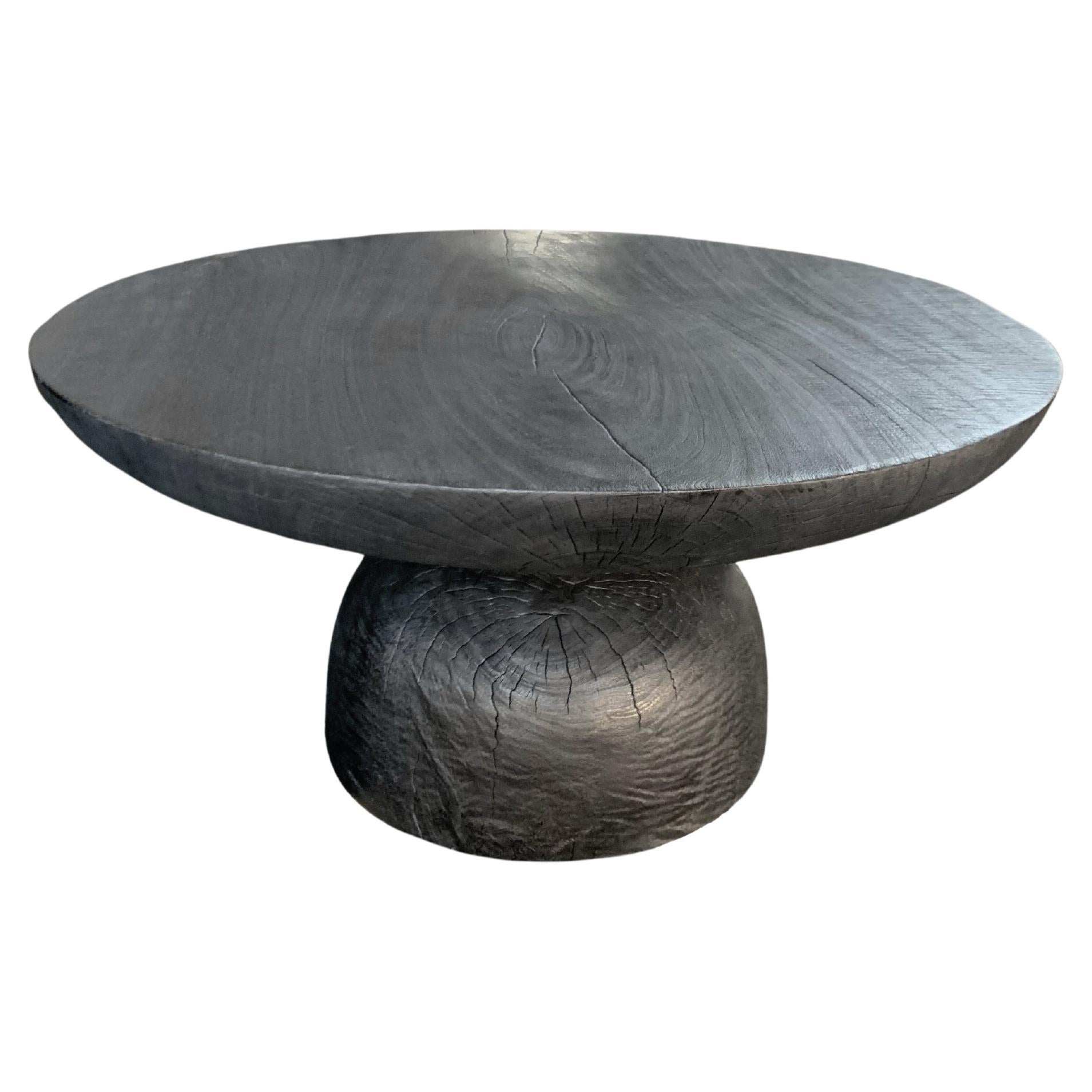 Table ronde sculpturale en bois de Mango, finition brûlée, organique moderne