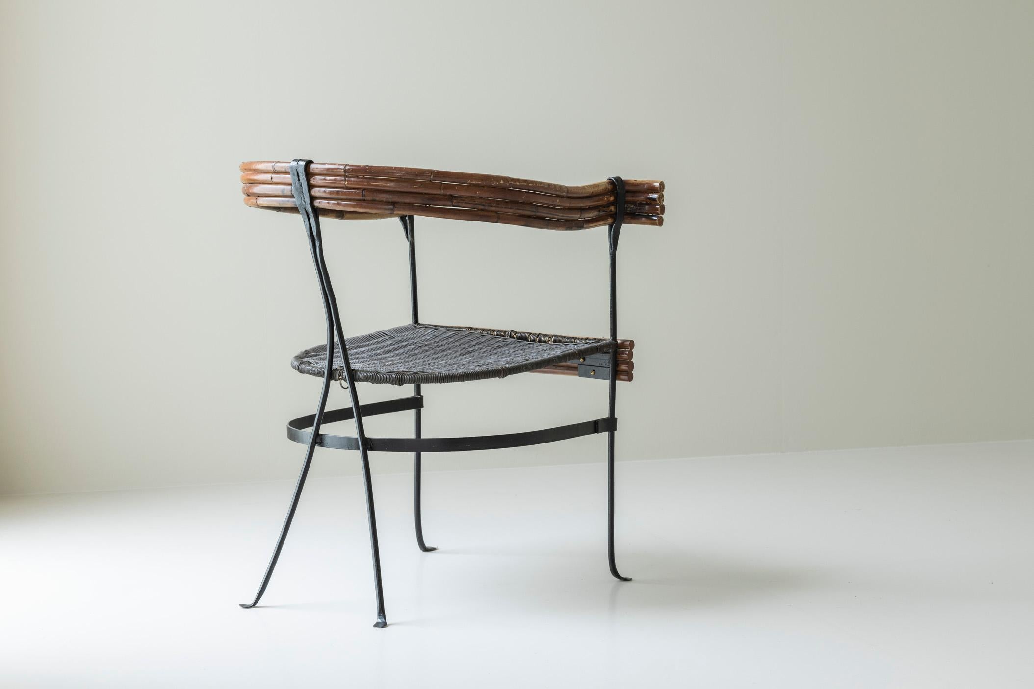 Fauteuil rustique sculptural provenant de France, datant des années 1960. Doté d'une structure en fer forgé, d'une assise en cannage tressé, d'un dossier et d'accoudoirs en bambou, il s'agit d'une pièce unique et élégante qui donne du caractère à