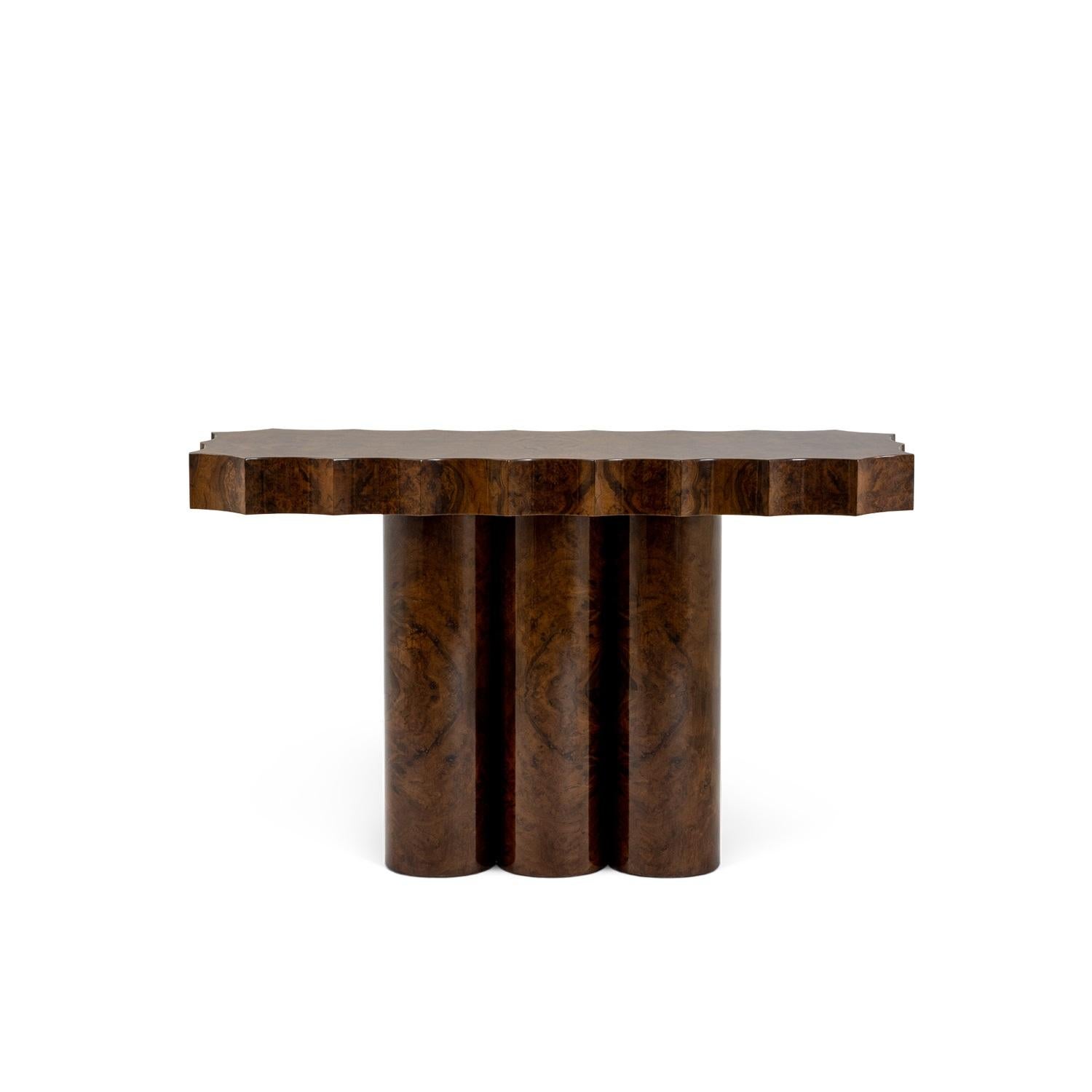 Una consolle davvero particolare, realizzata con uno splendido legno di radice di noce, che mette in mostra le sue venature con un'impeccabile finitura lucida. Il contorno del piano del tavolo è scolpito in modo unico con eleganti forme concave, che