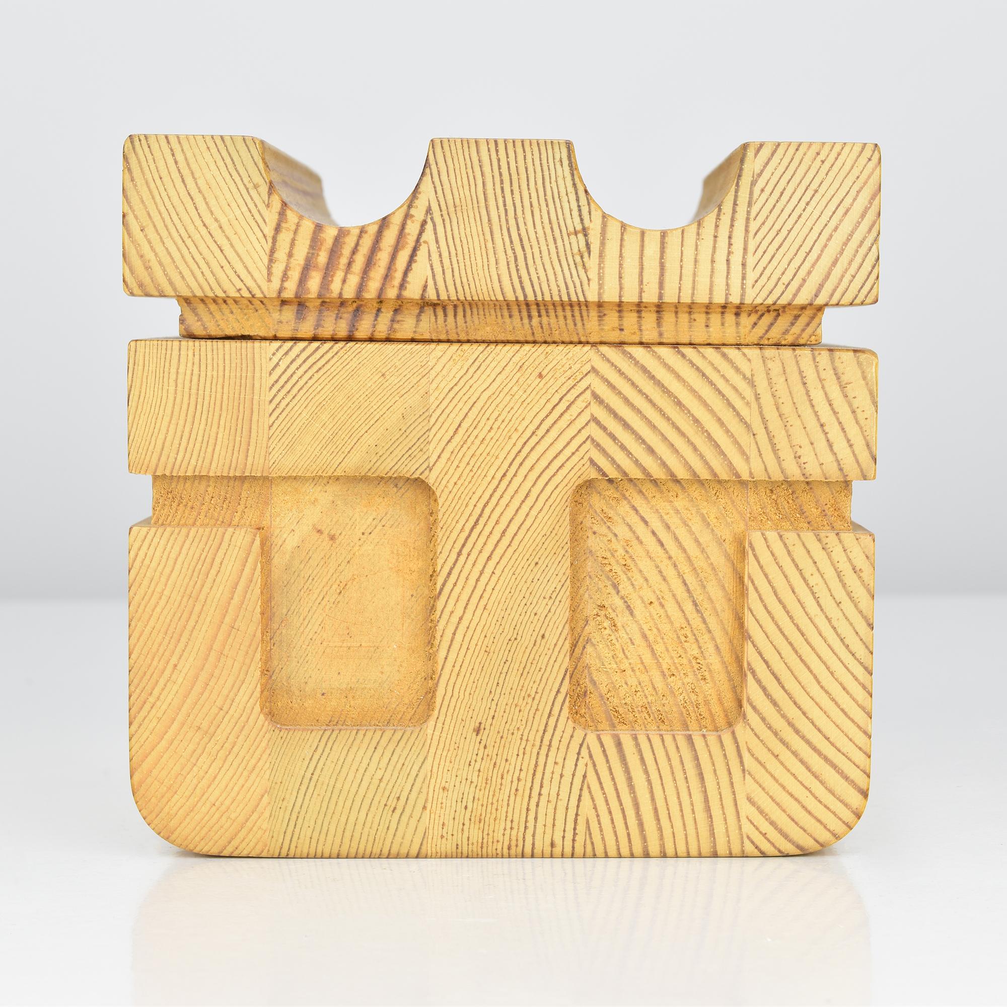 This sculptural Scandinavian lidded box is crafted from solid pine wood and features a striking architectural form reminiscent of the work of Uno Kristiansson and other mid-century Swedish designers. The box showcases beautifully aligned end-grain