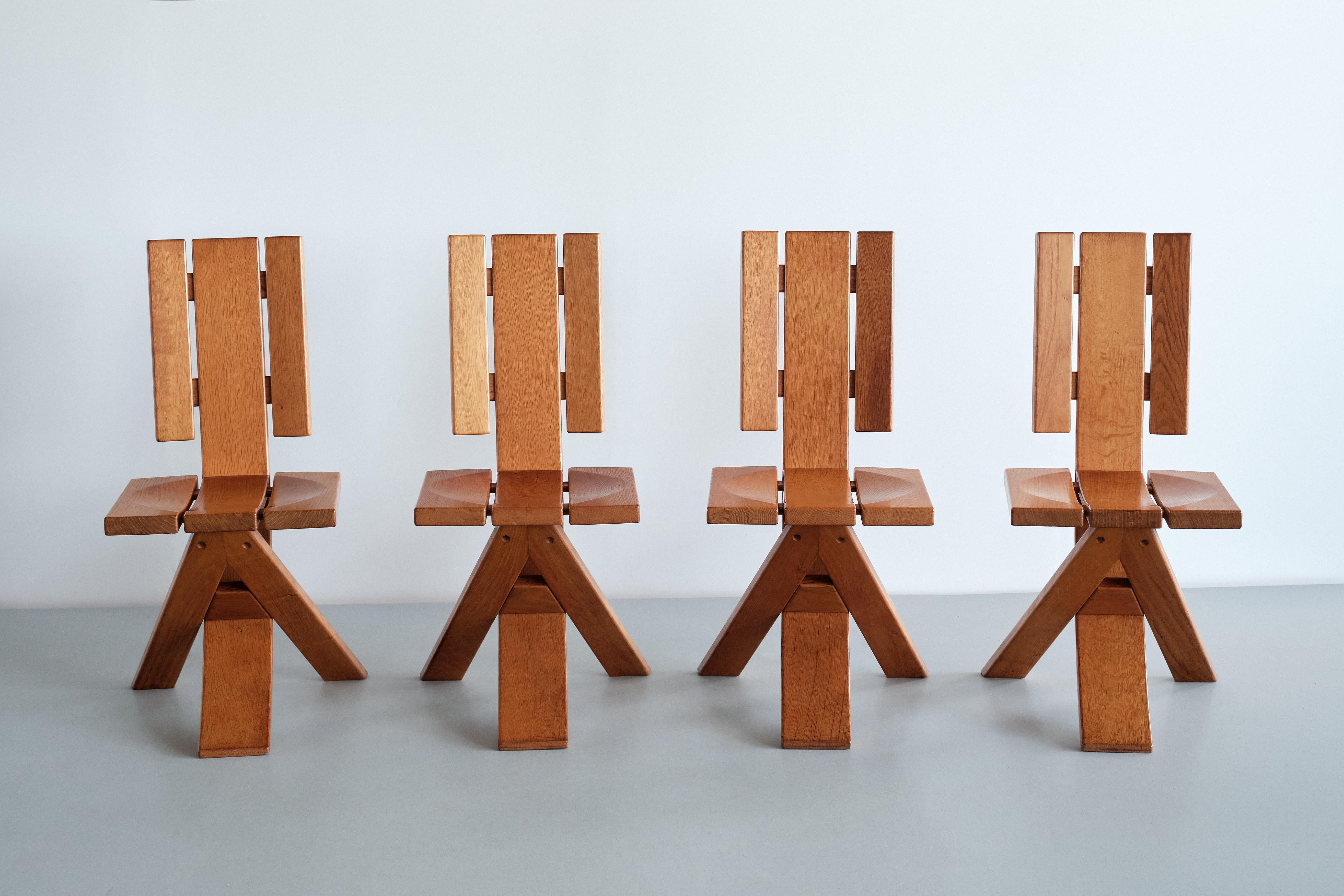 This striking set of four dining chairs was produced by the French manufacturer Ebénisterie Seltz in the 1970s. The design is executed in solid oak. The dynamic, contrasting lines of the three-legged base give the chairs a sculptural and attractive