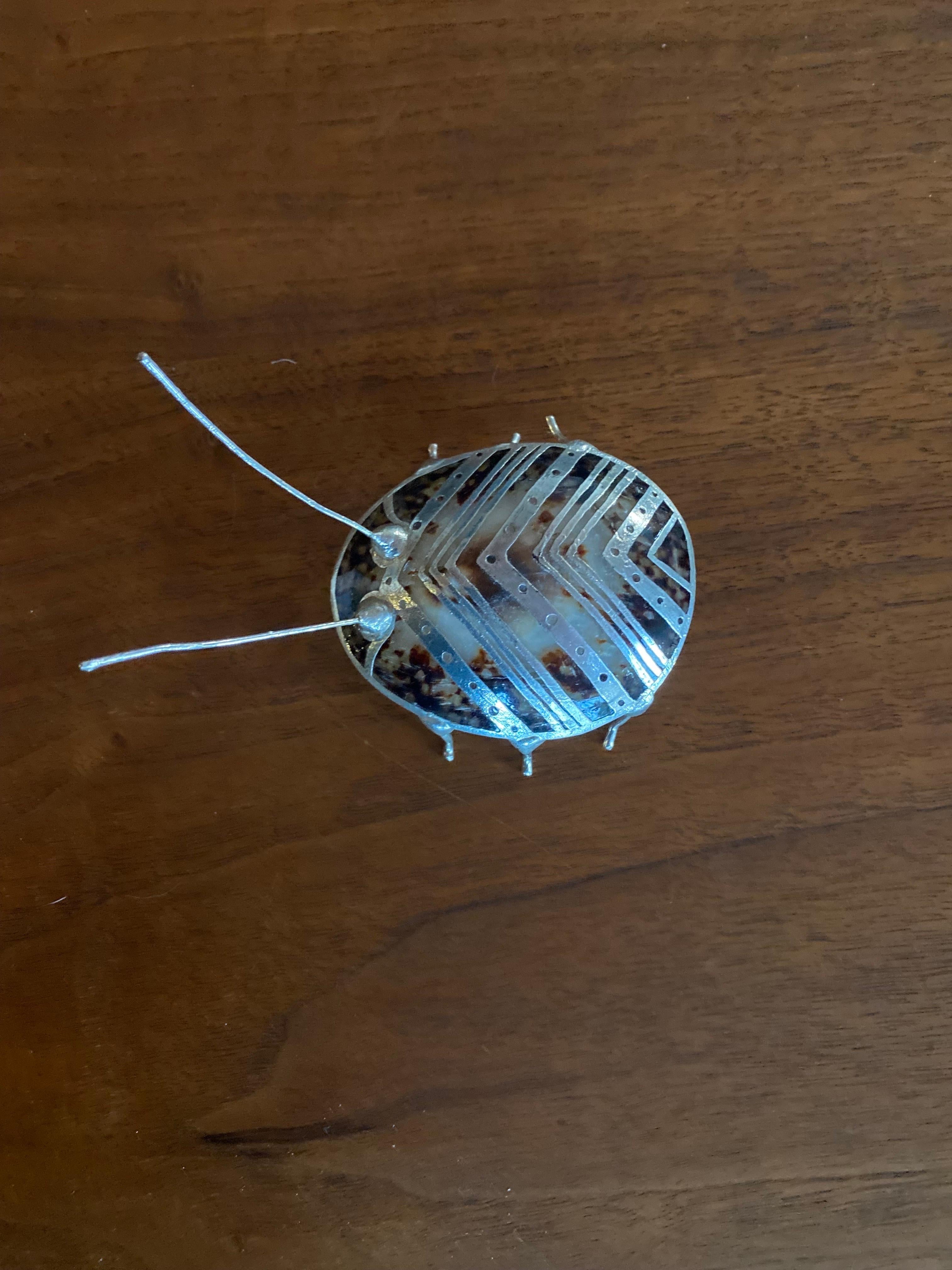 Bellissima coppia di figure scultoree di ortiche.  Queste figure sono realizzate in conchiglia e con dettagli in metallo accuratamente lavorati.  Gambe e baffi in metallo grezzo brillano di vitalità e luce.  Le linee geometriche giocate sulla