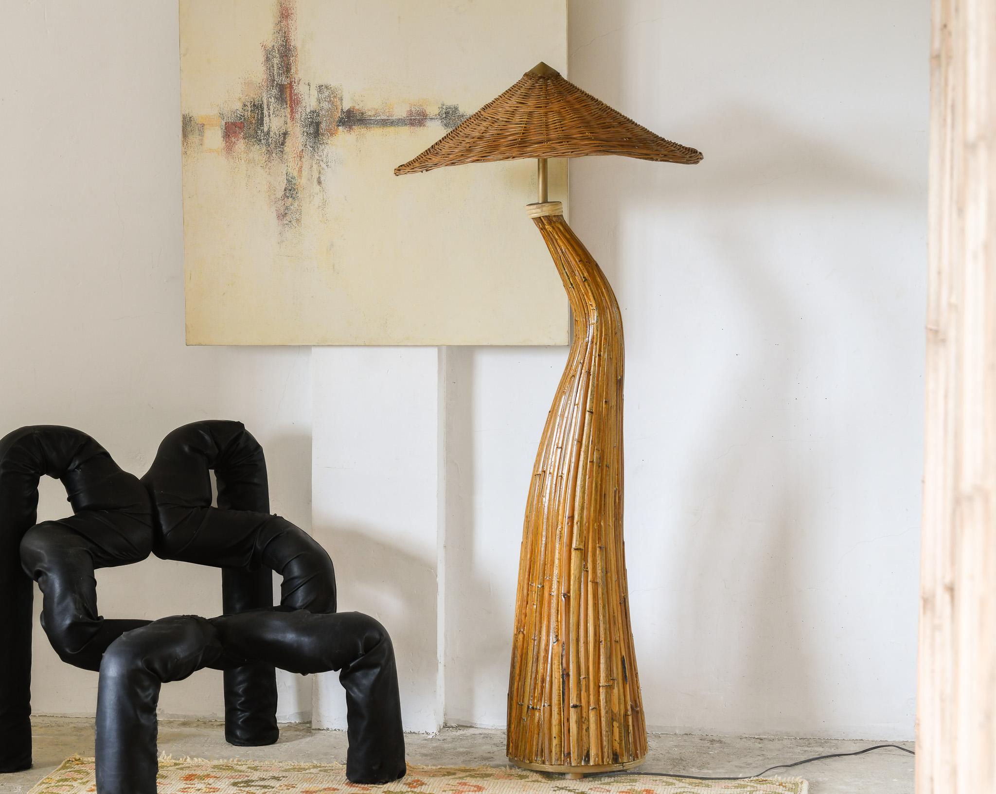 Ce superbe lampadaire en rotin est une pièce exquise du milieu du siècle, fabriquée de manière experte avec une forme organique de champignon et une finition laquée. De l'abat-jour en rotin tressé aux courbes impressionnantes, c'est la pièce