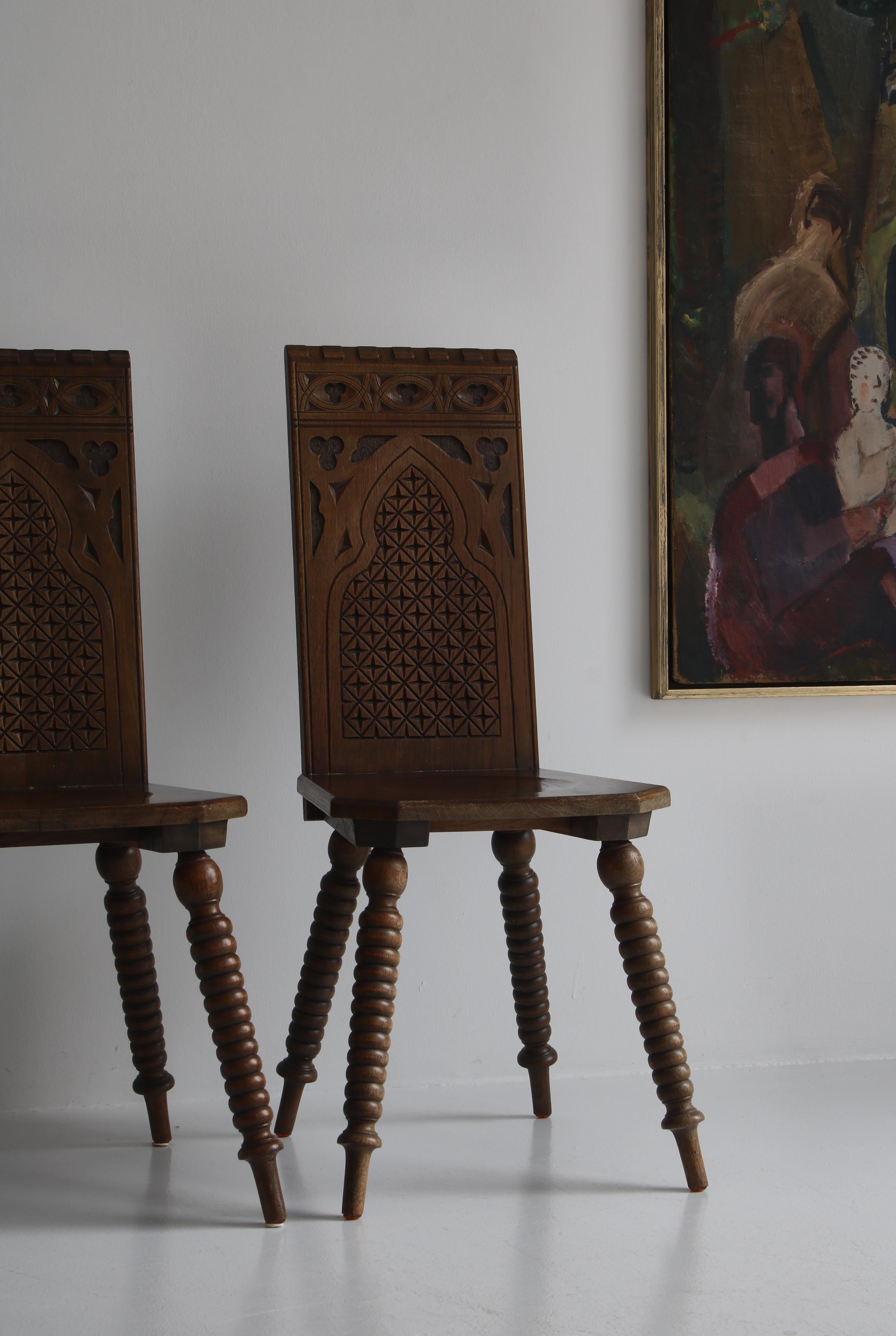 Amazing pair of side chairs in modern baroque style by a Scandinavian cabinetmaker in the early 20th. century. The dark stained oak are masterfully carved and decorated with abstract motifs. The chairs have a distinct expressions that adds
