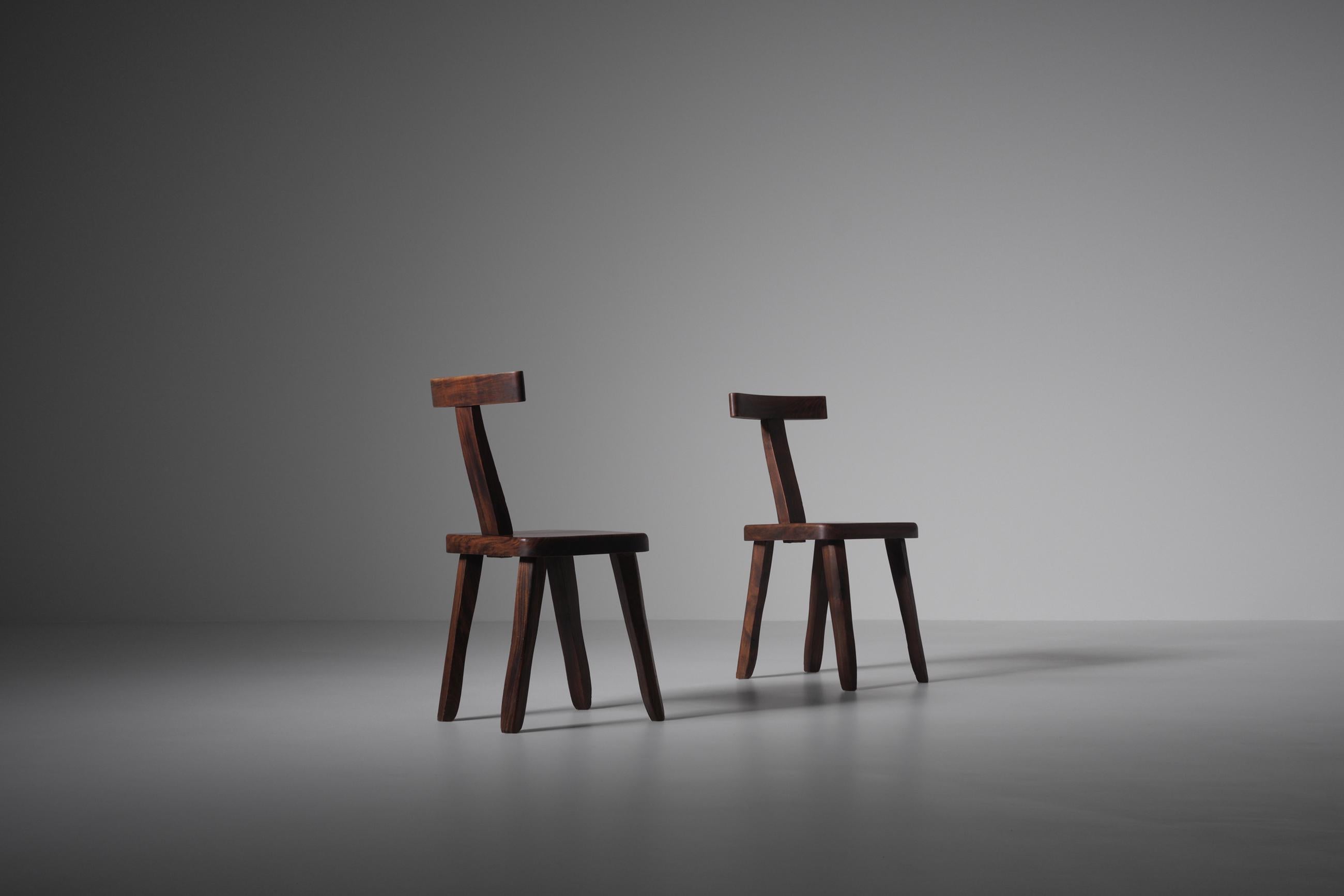 Set of two sculptural side chairs often attributed to Olavi Hänninen but actually a French production of the 60s. The chairs are constructed out of dark stained Elm wood with nice warm tones. Every single element of the chairs is carved by hand,