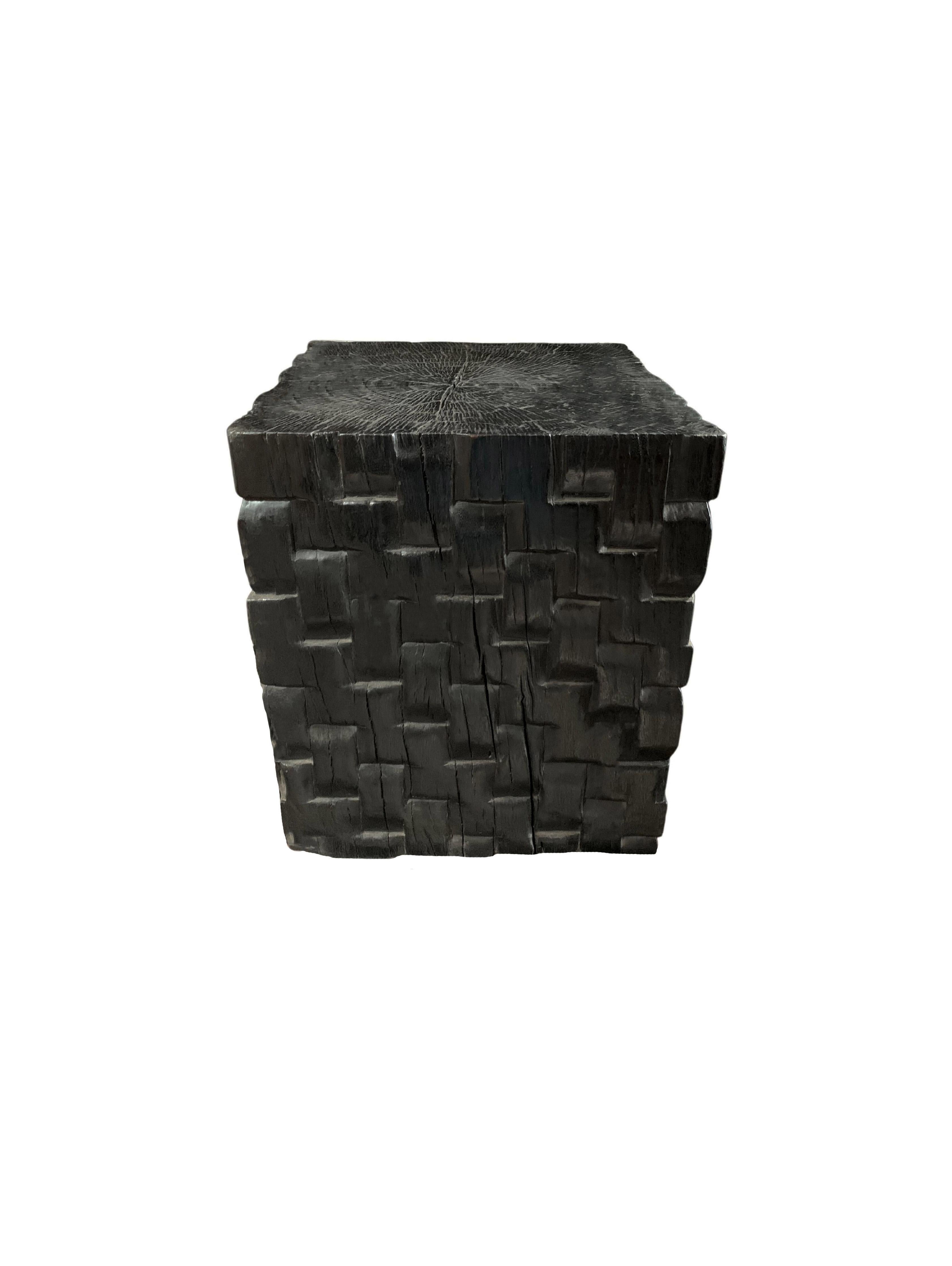A wonderfully sculptural side table with a woven pattern hand-carved on four sides. Its rich black pigment was achieved through burning the wood three times. Its neutral pigment and subtle wood texture makes it perfect for any space. A uniquely