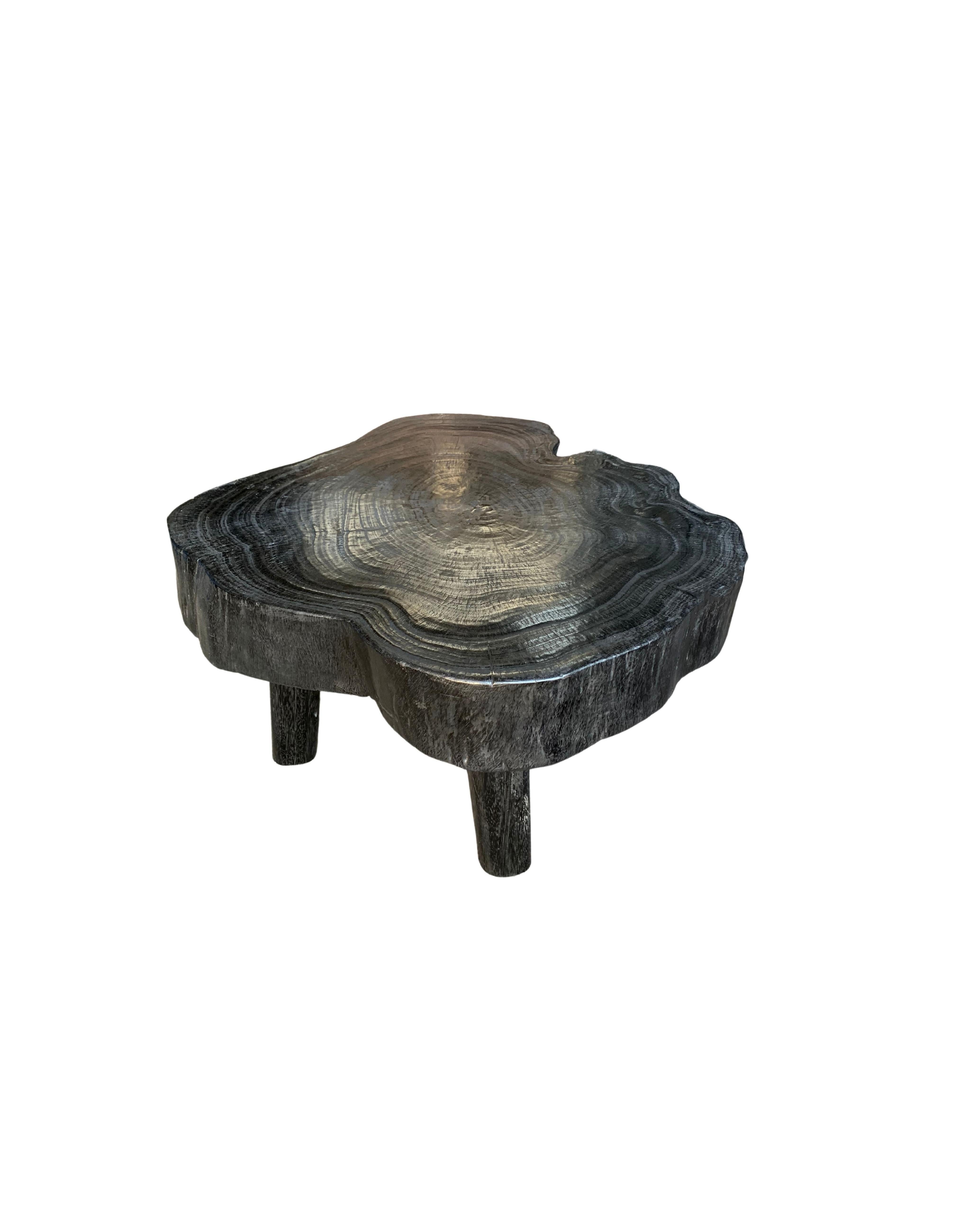 A wonderfully sculptural side table with an organic form. Its stark black pigment was achieved through burning the wood three times. Its neutral pigment and wood texture makes it perfect for any space. A uniquely sculptural and versatile piece